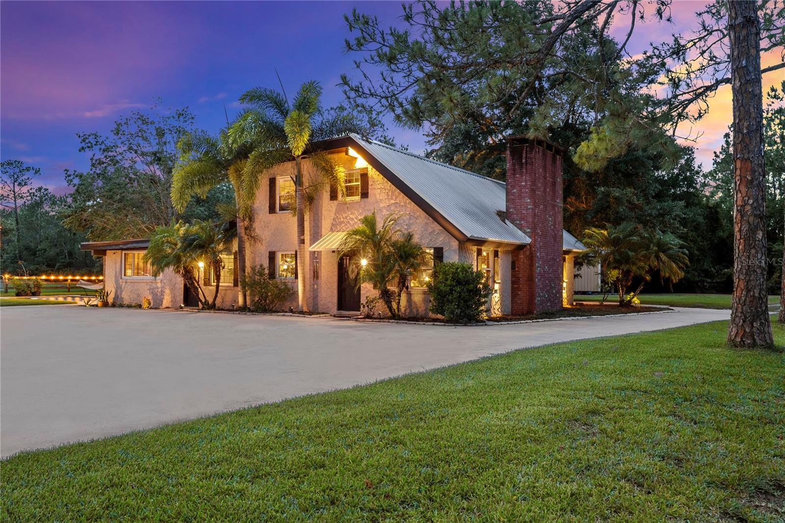 LOCATION, LOCATION!!! This charming country estate is situated on 6 acres of cleared, mowed, and fenced land and includes its own fish-stocked pond. Simply picturesque! This private countryside retreat is just minutes away from the Port Orange Pavilion, shopping, schools, I-95, I-4, and both Daytona and New Smyrna Beaches. The primary residence is full of character, featuring wood tongue-and-groove ceilings with support beams throughout. The flooring is ceramic tile downstairs and wood plank upstairs. Enter the main home into an open-concept living and Dining Room combination, anchored by a large wood-burning Fireplace with a solid wooden mantle and Brick Hearth. The Valuted Ceilings are impressive, and the custom Iron Railing on the open second-floor catwalk staircase is beautiful! The Kitchen is large with abundant cabinet space. There are newer Stainless Steel Appliances for the cook in the family to utilize. The Office/Den/Sitting Room/additional Dining/ Room is a flexible space for the owner to define their needs. Step into the open and large Great Room filled with natural light that has a Summer Kitchen including an indoor grill, double sink, and bar. The French Doors open onto the Paver Patio and Pool Deck with the stunning newer Saltwater Pool. The pool has luxurious additional features of a Waterfall Fountain, Bubblers, Bench Seating, Pool Lighting, and Bench Stairs for entry and stacked seating. This area is an entertaining delight! On the first floor, the Primary Bedroom is located with an adjacent Bathroom. The large Bath vanity has a designated make-up area. There is a walk-in tiled shower and a newer stool. Upstairs, the two secondary Bedrooms share a Jack and Jill bathroom. The estate has several additional Buildings. The DETACHED OVERSIZED TWO-CAR GARAGE has an "IN-LAW BEDROOM, BATHROOM SUITE, with an area for a small Kitchenette. Currently, it has a refrigerator. There is also a large BONUS ROOM with a HALF BATH. This room is being utilized as a game room with a Pool Bath; however could be the 5th bedroom, art studio, man cave, personal gym, etc. The BARN is divided by a concrete walkway, has multiple stalls, and two tack rooms. The property also has a tall-ceilinged POLE BARN that is partially sided with a 1/2 concrete floor, perfect for parking many vehicles, boats, large equipment, etc. This structure has water and a 30-amp RV hookup. The SHED also has electricity for convenience. Zoned A-2, this well-maintained estate is both beautiful and versatile to meet your dreams. Sellers are offering a one-year Old Republic Home Protection warranty plan with an accepted buyer contract. Contact me to learn more and schedule your tour. Let's work together!