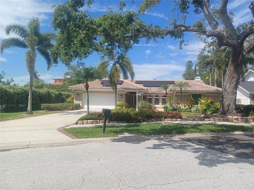 There was no flooding to this property from the hurricanes in 2024. The Kensington Oaks subdivision reflects pride of ownership. This is a mature tree-lined neighborhood with underground powerlines. This 2,765 sq. ft., open concept home offers high vaulted ceilings, featuring 3 bedrooms, 2 baths with a 3rd. full bathroom for guests near the screened swimming pool. As you walk from the outdoor kitchen, the covered lanai leads to an additional custom built 3 car climate-controlled, 864 sq. garage with side paver parking pad. There are 3 bays with 2 lifts and an air compressor system. Use your imagination to transform the rear custom garage into a separate office, workshop, fitness gym or game room with pool table. Additionally, there is an attached 2 car garage at the south facing front of the home. Multiple solar panels, a sum pump, a Generac Generator, Travertine Floors, hurricane windows, granite countertops and stainless steel appliances. Enjoy the tropical landscaping which provides privacy on this .41 acres corner lot.  The HOA includes great neighbors, garbage, recycling with yard debris pick up. Located minutes from Indian Rocks Beach, shopping and restaurants.