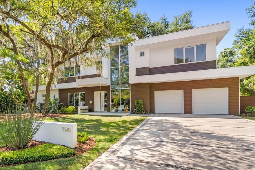 Located in Winter Park this home was devised by architectural firm, Green Apple & built by E2 Homes. Contemporary living adheres to a few principles that define its simple aesthetic: open-floor plan, clean lines, minimal clutter & a neutral color palette.  This four bedroom, five bathroom almost 4,000 square foot, custom built pool home delivers on all of those principals & more. The bold, modern shell is composed of a warm, walnut toned wood, smooth finished white stucco & floor to ceiling large scale windows. It sits on a wide, expansive lot where low maintenance, organic style plant material was installed & where a breadth of other exterior materials were used such as zoysia, large square cement drive and walkways bordered by Alabama limestone chips that nicely compliment one another. The interior design continues to push the envelope & reimagine life within its walls.  Through the custom front door your guests will arrive in the foyer where they will be greeted by an architecturally significant solid walnut, floating staircase & statement, pendant style light fixture both of which are showcased through the two story windows at the front of the home. To the left is a den or office that can be privatized by closing the double pocket doors. Moving forward the home opens to the living, dining, kitchen and outdoor spaces. The main area flooring is polished cement & that flooring continues to the covered outdoor space reinforcing the seamless connection between them.  The kitchen was designed in collaboration with S&W where the cabinets were sourced. The Hanstone quartz countertops are Royale Blanc; a clear ivory that provides a harmonious ambience, unfettered by patterns or design. Masterpiece series, stainless steel Thermador appliances including a gas fueled cooktop with five burners, vent hood, double ovens, counter depth refrigerator/freezer & dishwasher. Two under counter, built-in wine refrigerators & microwave located in the hidden pantry are also included. The living & dining areas open via floor to ceiling, multi panel sliding glass doors to the deep, covered outdoor living space & Summer Kitchen.  The Summer Kitchen features a professional DCS outdoor grill and sink with the smart design and functionality of a sliding glass pass through to the kitchen.  The dreamy outdoor living has many of the interior comforts.  The saltwater & heated pool, spa and natural gas fueled fire feature with seating area and composite deck for lounge chairs are almost entirely surrounded by mature bamboo for the ultimate privacy resulting in what feels like a backyard sanctuary. The primary bedroom suite, located on the first floor, has beautiful views of the lush backyard with motorized window treatments.  The spa like bathroom features a vanity with quartz countertops, double sinks, a large stand alone bathtub, private water closet, spacious shower tiled with Calacatta Gold marble & multiple shower heads as well as a large closet customized for optimal storage.  Upstairs you will find a loft & guest suite on the right side of the home & two bedroom suites on the left. The home is completed by an oversized & attached two car garage, parking pad, laundry room with significant storage, a hidden pantry with custom organization, Storch Entertainment A/V package with flat screen televisions mounted to the wall, sound bar, surround sound speakers, Apple TV for streaming content, etc. This luxury custom home is available for private showings now.