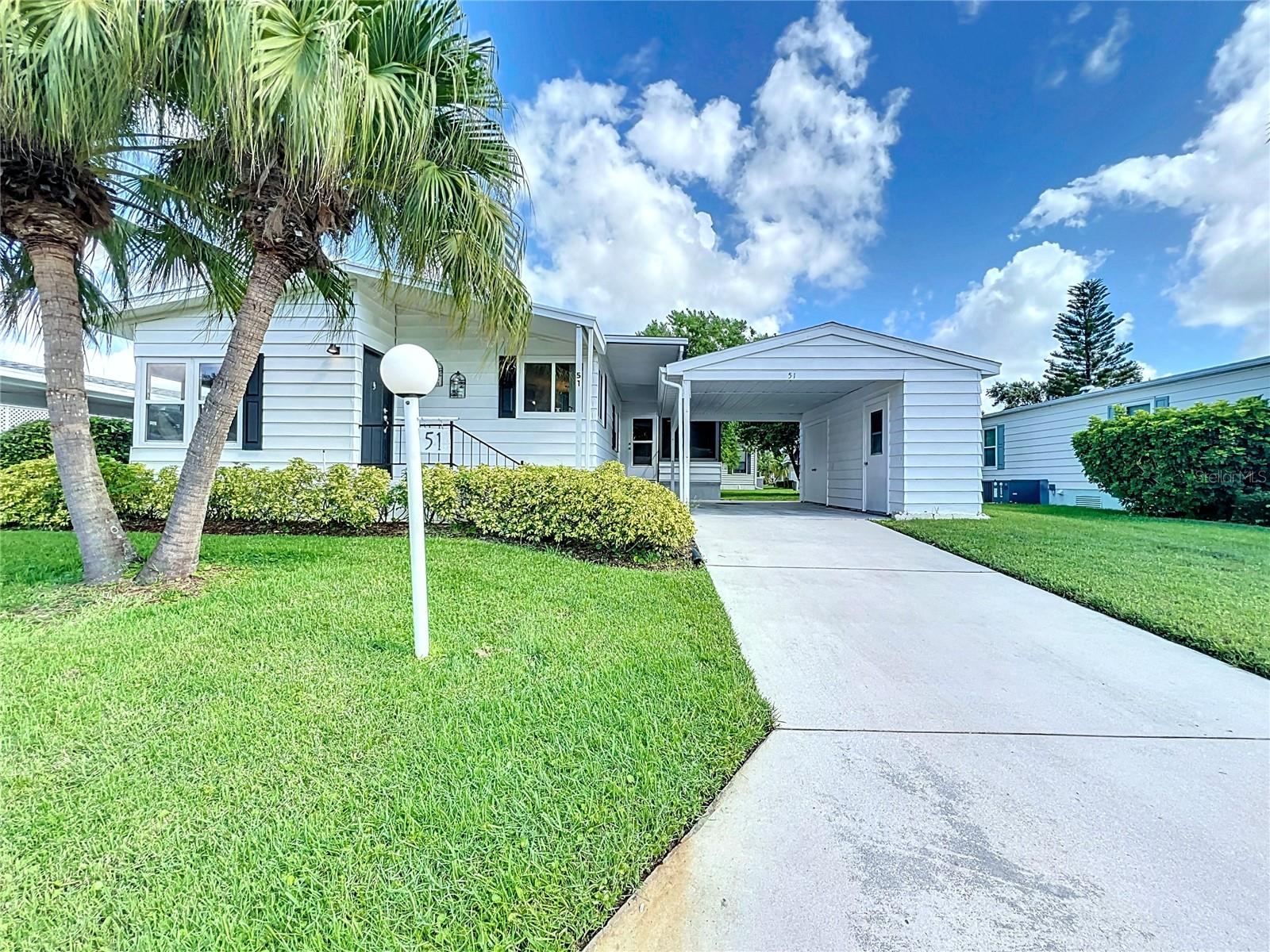LAND OWNED! UPDATED & FURNISHED 2 BEDROOM, 2 BATH HOME IN ACTIVE 55+ COMMUNITY! Inviting floor plan with coastal cottage decor throughout. COMPLETELY NEW KITCHEN (2024) with stainless steel appliances, quartz countertops, wood shaker cabinets, closet pantry, breakfast bar, and a bright sink area with large corner windows. The adjacent dining room has a wall of lighted built-in cabinets. Plenty of room for entertaining in the ample living room. The spacious primary bedroom has a walk-in closet and en suit bathroom. That primary bathroom features a tiled shower with new plumbing fixtures and dual sink vanity with quartz countertop. Laundry room is also off the primary bedroom and includes a never used all-in-one washer/dryer unit. Charming second bedroom with walk-in closet. Vinyl plank flooring throughout. Enclosed side porch with sliding windows and tile floors. Carport. Storage shed with electricity and utility sink. Shingle roof (Nov. 2016). Central A/C (2022). Double-paned vinyl windows. Vapor barrier, tie downs, and longitudinal stabilizers are all ready for foundation inspections. The PET FRIENDLY community of Ridgewood Oaks offers a heated pool & spa, 24-hour guarded gate, clubhouse, tennis courts, pickle-ball courts, shuffle ball courts, covered outdoor fitness equipment, and plenty of opportunities to make new friends. Ridgewood Oaks is near retail, dining, worship, the public library, outlet malls, I-75, and of course the Manatee River. NO LOT RENT! Quarterly fees are $731 and include internet, cable, trash, & grounds maintenance. This property may also be leased with no waiting period. SO MUCH TO OFFER!