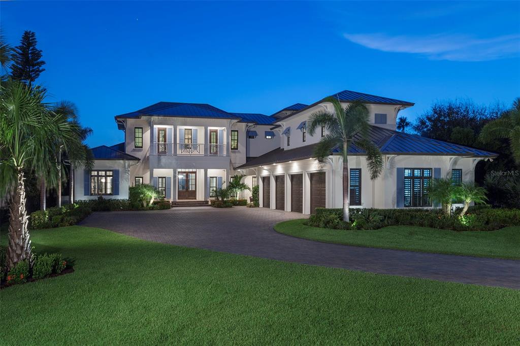 THE FINEST HOME AND LAND COMBINATION IN NEW SMYRNA BEACH
A rare opportunity to acquire this one-of-a-kind custom home built by award-winning builder Dave Brewer Homes. It is the epitome of tasteful luxury located on one of the largest Intercoastal Waterway (ICW) lots in the highly sought-after North Beach area of New Smyrna Beach. The western exposure features a forever view and stunning sunsets every night. Passing through the gates you will find magnificently manicured tropical landscaping that leads you to a large circular motor court and a four-car collectors dream garage. The moment you step through the front doors your eyes are greeted by expansive windows overlooking the ICW and a resort-style infinity edge pool. Hardwood, brick and marble are complimented by custom-woven area rugs throughout the main floor. This spectacular 6112 square foot home features four bedrooms, four full baths and two half baths. The gourmet chef’s kitchen has top-of-the-line stainless steel appliances, a large center island, hand crafted custom hood, a hidden 5 x 10 pantry and an adjoining casual dining space. The wet bar features a striking artisan glass “wave” top. The climate-controlled wine room with custom built-in cabinetry can accommodate 400 bottles. There’s a dedicated Home Theater Room with surround sound, a 4K projection TV and seating for eight in reclining leather theater chairs. The main floor master bedroom has a picturesque view of the ICW and direct access to the lanai, pool and spa. Open the triple sliding doors off the great room to access an 800 sq ft fully screened outdoor living space with a vaulted ceiling, gas fireplace, fully equipped summer kitchen, a large island/bar and a half bath. The saltwater infinity edge pool has a child’s wading area and an elevated spa overlooking the ICW and an adjoining patio with a gas fire pit. The covered dock with power, water and an electric lift can accommodate a 28 ft boat. There’s an attached floating dock for easy water access for SUP, kayak launch and swimming. The oversized four-car garage has a fully finished interior including flat screen TV, insulated garage doors, hot/cold running water, steel mechanic’s cabinetry with integrated rolling tool cabinets, a hardwood work bench, WeatherTech flooring and a 7,000 lbs. car lift to accommodate a fifth vehicle. This stunning estate is two blocks from the beach and an easy walk to Flagler Ave where you will find shopping, nightlife and restaurants. This is New Smyrna Beach luxury resort living at its absolute finest.
