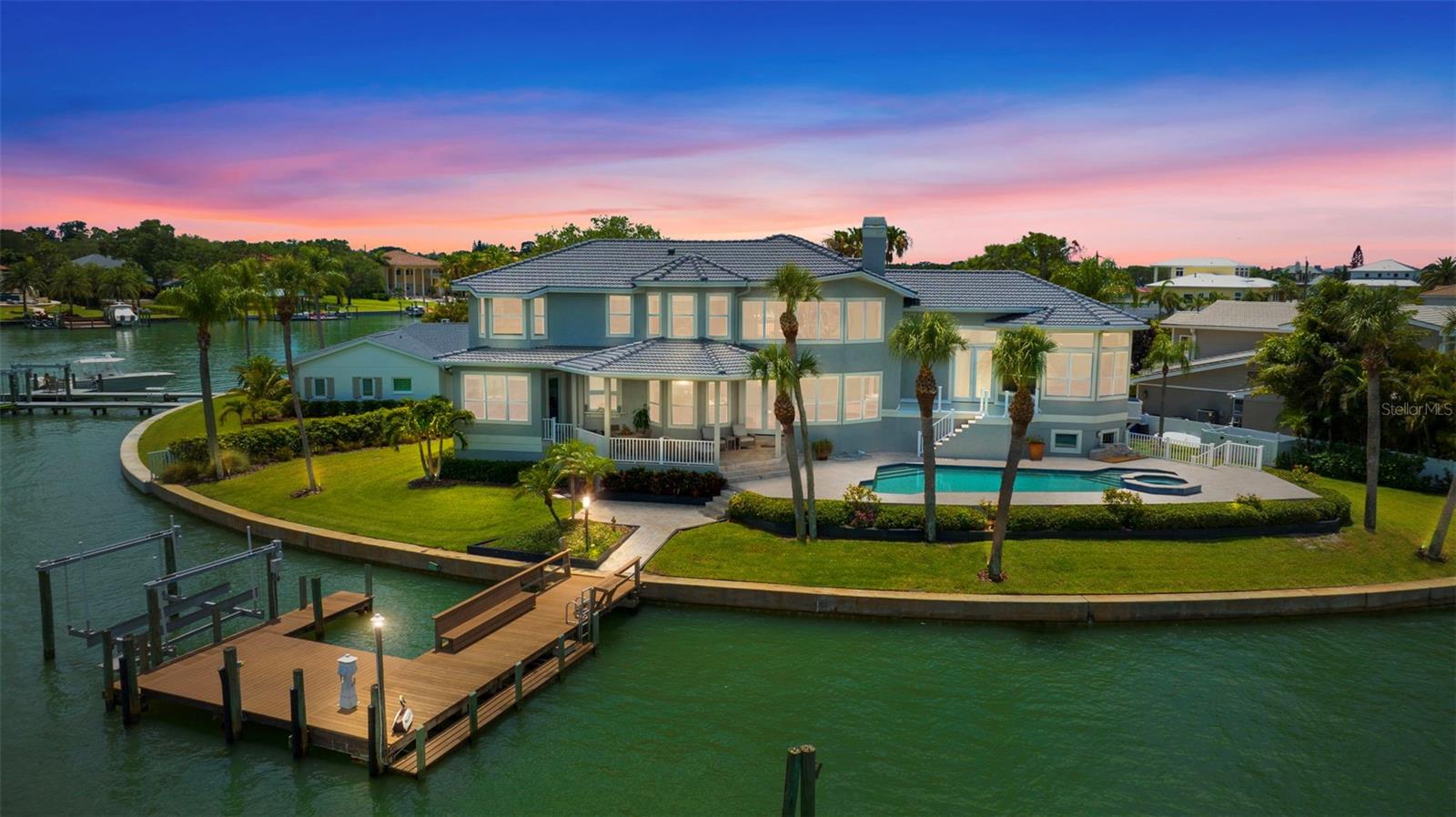 Embracing an enviable setting at the end of a quiet cul de sac, this majestic waterfront compound offers unparalleled water views and meticulously updated interior features. With its understated elegance and timeless design, this residence showcases spacious, light-filled rooms that artfully highlight the panoramic vistas of the water. Step into the formal living room, where 20-foot ceilings and a cozy fireplace create an atmosphere of refined comfort. The epicure's kitchen is a culinary haven, boasting chef-grade fixtures, stainless appliances, a stunning maple center island, Cambria quartz countertops, and custom wood cabinetry, providing both functionality and style. At the end of each day, find solace in the master suite, a true sanctuary of tranquility. Enjoy a luxurious walk-in closet, an oversized spa-like master bathroom, and breathtaking views that enhance the sense of serenity. On the second level, three additional bedrooms offer ample space for family or guests. Outside, indulge in the pleasures of the saltwater pool and spa, where you can relax and rejuvenate amidst the soothing waters. The stone patio provides an idyllic setting for al fresco dining, creating memorable moments while embracing the gentle coastal breeze. The dock, equipped with a 9,000-pound boat lift and deep water mooring, caters to larger vessels, ensuring easy access to unforgettable boating experiences. This exceptional property truly epitomizes the entertainer's dream, offering captivating experiences for both family and friends, on and off the water. Immerse yourself in the splendor of waterfront living, where luxury, tranquility, and natural beauty unite to create an unrivaled lifestyle.