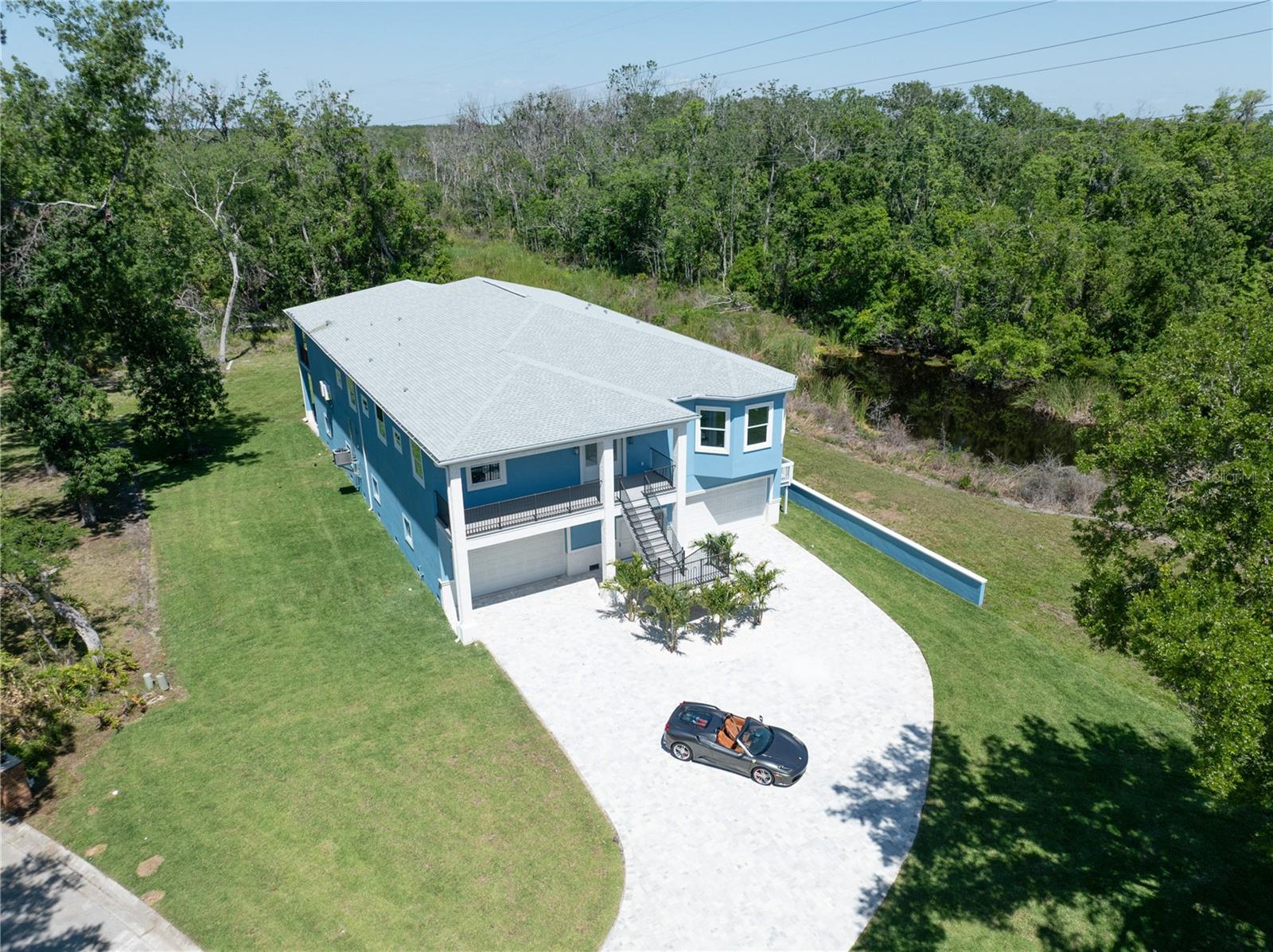 One or more photo(s) has been virtually staged. Welcome to your own slice of Florida paradise! This charming BRAND NEW Key West-style home is tucked away on a quiet cul-de-sac in Tarpon Springs, offering a perfect mix of space, comfort, and location. With 4 bedrooms, each with their own private en-suite bathroom, plus an additional half bath, there’s plenty of room for family and guests to spread out and relax. Inside, you’ll find a expansive floor plan, that seamlessly connects the living, dining and kitchen areas - perfect for modern living and entertaining. Boasting with 4,723 SQ FT of living space, you'll enjoy high ceilings, abundant natural light, and thoughtful architectural design. The large master suite is a highlight, with a spacious bedroom full of natural light, two walk-in closets, and a beautifully designed bathroom featuring dual vanities, a soaking tub, and walk-in shower. Enjoy the outdoors with two balconies, a welcoming front balcony and a peaceful back balcony overlooking mature trees. It's a perfect spot for your morning coffee or evening wind-down. One of the biggest bonuses is no HOA—giving you the freedom to truly make this property your own. Need room for your toys or hobbies? The massive 5,149 SQ FT garage has you covered—ideal for car enthusiasts, boat storage, a workshop, or extra space. The oversized lot is surrounded by trees and backs up to peaceful ponds, giving you a private, secluded feel while still being 5 minutes to Lake Tarpon, 10 minutes to the restaurants, bars, and waterfront fun in Tarpon Springs. This is a rare opportunity —spacious, private, and no neighborhood restrictions. Come see it for yourself and picture the possibilities. Icing on the cake? The seller is also the builder, so some modifications or changes within reason are totally possible!
