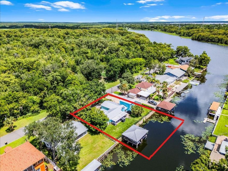 Spacious Waterfront 4BR/3BA with In-Law Suite & Dock – Prime Sanford Location!

This beautifully updated 4-bedroom, 3-bath home sits on a rare half-acre lot-and-a-half with direct canal access to the St Johns River, featuring a concrete seawall, private boat dock with boat lift, double jet ski lift, and ample space to relax by the water.

The 2019 addition offers flexible living options: use it as a private in-law suite with its own entrance, or as a home office or studio with separate access from the main house. The home features hurricane-impact windows and doors, a durable metal roof, and upscale interior touches like crown molding and designer finishes typically found in luxury homes. Poured concrete safe room/panic room.

Enjoy the spacious screened-in porch, perfect for entertaining or peaceful mornings overlooking the water. The property also boasts plenty of parking, mature landscaping, and room to roam—larger than most lots in the neighborhood.  30 Amp RV parking spot on the side of the house.

Conveniently located just minutes from I-4 and the 417/Greenway, you're close to shopping, dining, and everything Central Florida has to offer. Nestled in Sanford, this location is perfectly positioned between Orlando and Daytona, offering the best of both worlds.

Don’t miss this versatile, upgraded home with waterfront living and room to grow!