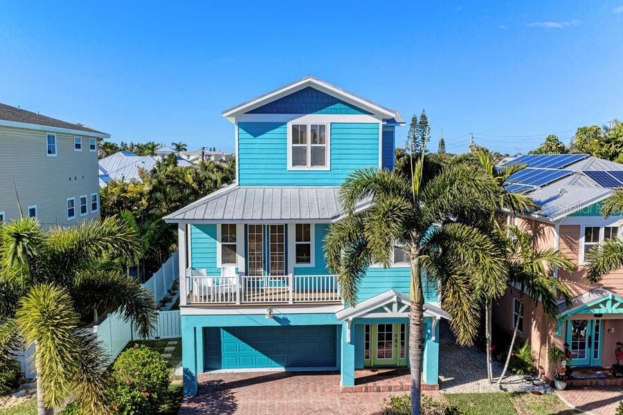 Key West Style Home, centrally located in Holmes Beach, has quality finishes throughout including solid wood cabinets, volume ceiling and granite countertops. The property is being offered turnkey furnished with beachy, coastal decor. The home offers an elevator that services all three levels. A large garage offers plenty of space for parking and storage for beach equipment. The outdoor area features a covered patio, perfect for entertaining and a free form heated pool. Mature, tropical landscaping creates a private backyard oasis. This home's location is ideal, only a short walk to many shops and restaurants, as well as the world famous beaches. This beach house would be a great primary home or a second home with income potential.