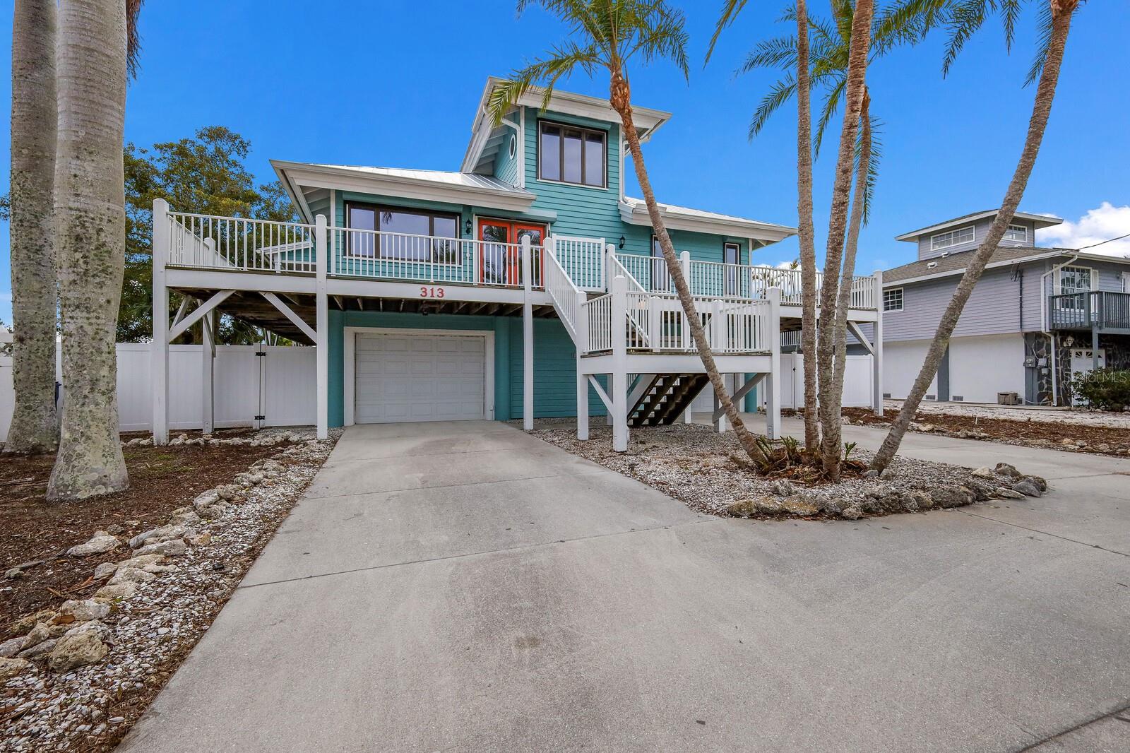 Experience the charm of waterfront living. This spacious residence offers breathtaking water views, ideal for a relaxed and comfortable lifestyle. Updated in 2016, the property features a third bedroom and a new bath. The kitchen, remodeled in 2014, is enhanced with new cabinetry and granite countertops. Vaulted ceilings throughout the home contribute to its expansive and airy feel, notably in the first-floor owner's suite with an en-suite bath and walk-in closet, and in the second bedroom with an adjacent full bath. Additional amenities include a bonus space with views of Tampa Bay, a cozy nook for peaceful moments, and a large screened lanai perfect for outdoor relaxation. The property also includes a boat dock and a launch spot for kayaks and paddleboards. Storage and workspace needs are met with two single-stall garages and a workshop, ideal for kayaks, bikes, beach toys, or other hobbies. Located just a short walk from the Gulf of Mexico and near local dining, shopping, piers and recreational spots, this home is a tranquil retreat for those seeking a waterfront lifestyle. With possible room for a pool and vast potential for personalization, it stands as a full-time residence or can easily be converted to a vacation home with short term rentals permitted.