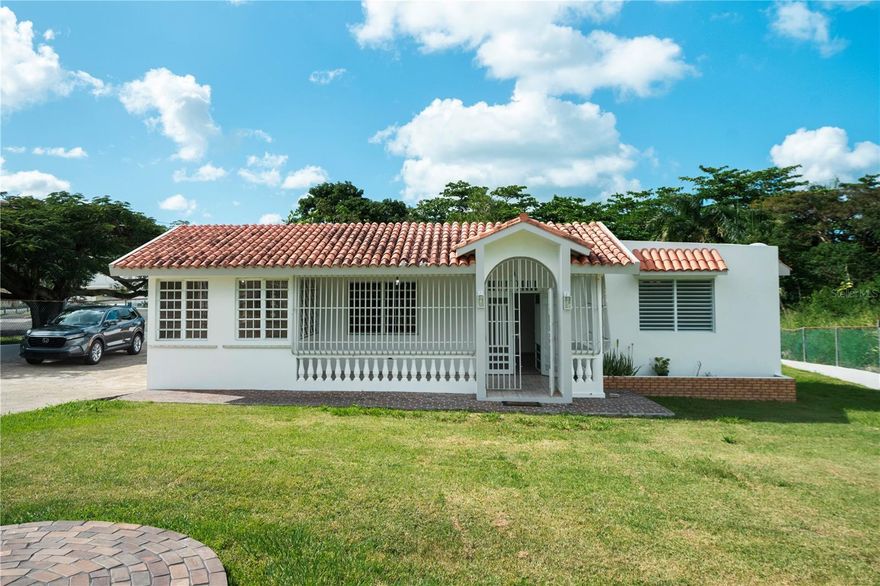 Single-story residence available for rent in Barrio Quebrada, Fajardo, offering a unique combination of interior space and expansive outdoor grounds. Set on a fully fenced lot of nearly half an acre, this property provides privacy, flexibility, and ample room for a variety of uses.
The home features over 2,000 square feet of living area, including three bedrooms, two bathrooms, a spacious living and dining area, kitchen, a dedicated laundry room, and an additional area ideal for a home office or flex space. Outdoor space is a key highlight, with a large yard and extensive parking capacity. In addition to a covered carport for two vehicles, the property offers space for more than five additional vehicles, making it ideal for tenants with boats, trailers, or multiple cars. Conveniently located in Fajardo with easy access to main roads, marinas, beaches, and essential services. Offered at $1,800 per month. Appliances, furniture, and utilities are not included. One-year lease preferred.