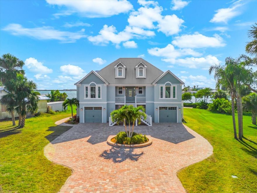 A luxury waterfront escape, built in 2016 with solid construction and set on over a half-acre, this five-bedroom, five-bath home is offered turnkey furnished—arrive and start living. Designed to sleep up to 15, it’s made for effortless hosting and unforgettable stays.

Calm water just steps away, with direct, no-bridge Gulf access. A covered 10,000 lb boat lift with electric and fresh water, plus a fish cleaning station, keeps every day on the water simple. The oversized heated pool and spa anchor a wide paver patio built for both relaxed afternoons and sunset evenings by the fire.

Inside, clean lines and thoughtful finishes define the space—tile floors, custom window treatments, and a beautifully appointed kitchen with granite countertops, soft-close cabinetry, stainless appliances, double oven, pot filler, and a large pantry. Multiple ensuite bedrooms and individual thermostats throughout offer comfort and privacy for every guest.

Upstairs, a loft with Murphy bed and full bath creates a flexible retreat, while the screened, covered Trex porch captures elevated water views and unforgettable sunsets. The lower level, non-conforming space adds bonus living with direct pool access, a game room, storage, and an additional bedroom and bath not included in the official count—ideal for overflow guests. Split garages for three cars and an elevator add everyday convenience.

Built to last with a metal roof and PGT impact windows, this home lets you focus on what matters—boating, entertaining, and soaking in the waterfront lifestyle.