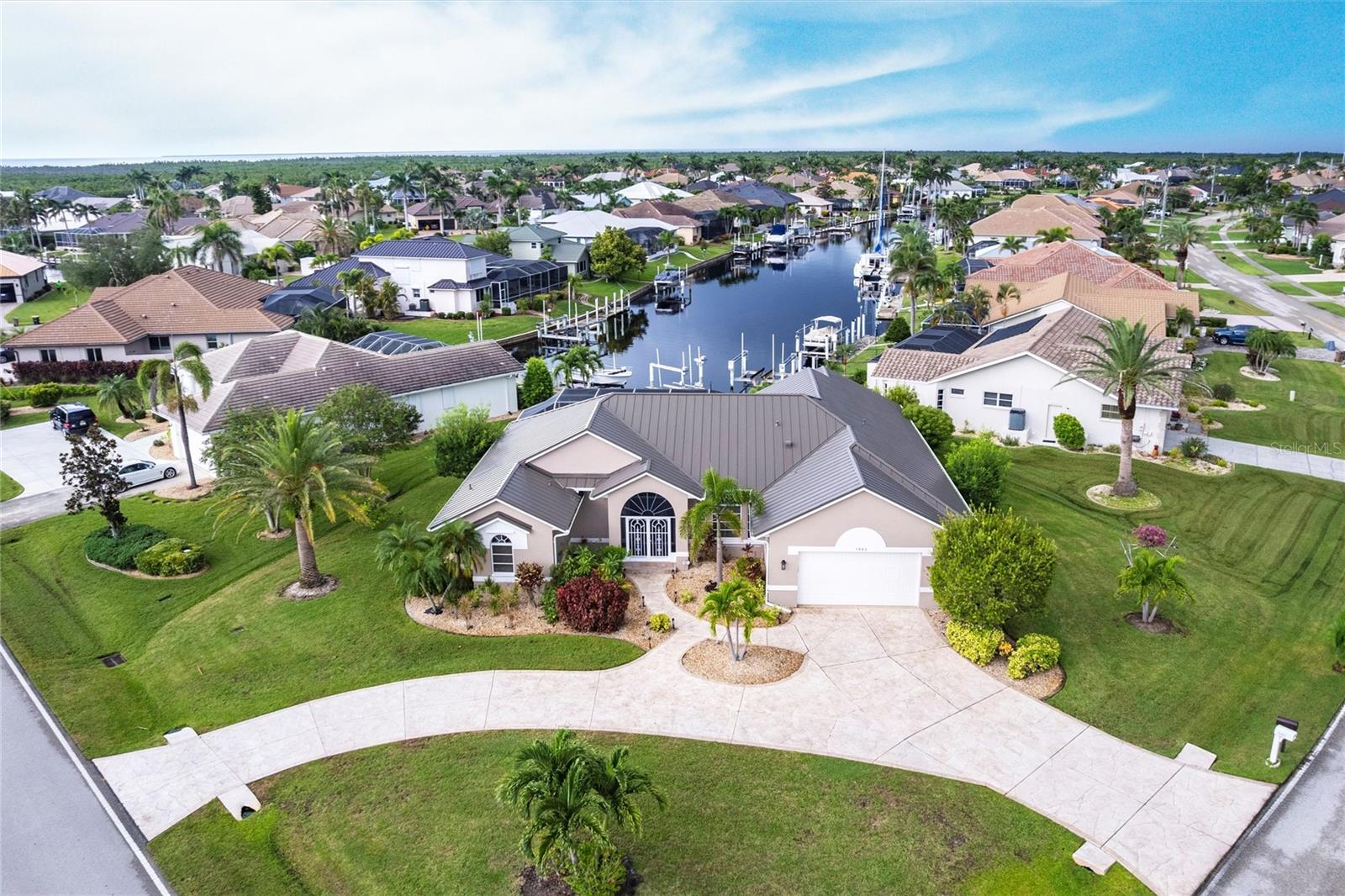 Welcome to your slice of Florida paradise! Nestled in the highly desirable Punta Gorda Isles, this waterfront residence is a true boater’s dream—offering quick open-water access in just minutes. Positioned on an oversized corner lot, this Tim Towles-built home has been meticulously maintained and offers 2,752 square feet of living space with an open, split-bedroom floor plan designed for both relaxation and entertaining. From the moment you arrive, you’ll notice the upgrades, including a new metal roof (2023), lush tropical landscaping with soaring palms, and a circular driveway that sets the stage for elegance. Inside, the formal living and dining areas feature soaring ceilings, wood-look tile flooring throughout, and a dramatic wall of sliding glass doors that frame sparkling water views. At the heart of the home, the kitchen features stainless steel appliances, granite countertops, hardwood cabinetry, a center prep island, breakfast bar, and a cozy dinette. Overlooking the dinette and spacious family room, this area is filled with natural light and offers multiple sliding glass doors from both the kitchen and family room that open to the pool and lanai, creating a seamless indoor-outdoor flow ideal for entertaining. The spacious primary suite offers private pool access, a sitting area, tray ceiling, and spa-inspired bath with a spectacular walk-in shower, jetted soaking tub, dual vanities, private toilet room, and ample storage. Two additional guest bedrooms with built-in closets share a full bath with an extended dual-sink granite vanity—perfect for family and visitors. Step outside to your private waterfront oasis. The oversized screened lanai showcases a sparkling pool, outdoor shower, covered lounge area, and accordion shutters for weather protection. Located at the end of the canal, the property features 35 feet of seawall, plus a 2019 concrete dock with a 10,000 lb. boat lift—providing everything you need for boating adventures. Additional highlights include hurricane shutters, A/C (2014), an oversized two-car garage, and a redesigned laundry/utility room now converted into a functional flex space with countertop and storage. The washer and dryer have been relocated to the garage, but the original hookups remain in place, allowing you the option to return the space to a traditional laundry room if desired. All just minutes from I-75, US-41, Fishermen’s Village, and vibrant downtown Punta Gorda with shops, dining, and waterfront activities. This spotless home is move-in ready—come experience the best of the Florida lifestyle today!
**PLEASE ENJOY THE 3D INTERACTIVE VIRTUAL TOUR ASSOCIATED WITH THIS LISTING**
