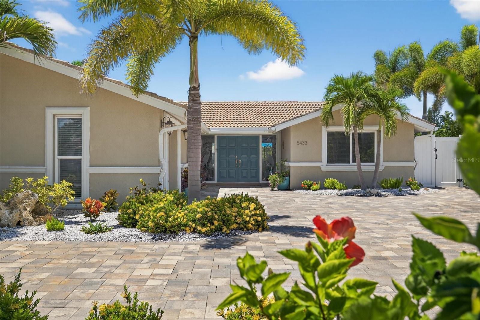 Welcome to the Good Life on Leeward Lane!
If you’ve been dreaming of a waterfront home that’s made for entertaining, soaking up sunsets, and living every day like a vacation—5433 Leeward Ln in Gulf Harbors delivers it all and then some. Set on a quiet canal with dolphins, manatees, and turtles as your neighbors, this tropical oasis brings you the very best of Florida’s resort-style living—from the waterfall in the saltwater heated pool to the custom outdoor kitchen and the BEST BONUS is the paid-off solar system that keeps your power bill around $30 a month (yep, really!).
As you pull into the pavered circular driveway, you’ll notice the curb appeal right away—lush landscaping, mature palms, and a welcoming double-door entrance. Inside, you’ll find a smart and stylish layout with plank tile flooring throughout, a split floor plan, and a light-filled kitchen complete with white shaker cabinets, soft-close drawers, walk-in pantry, and a built-in side bar/buffet that’s perfect for hosting.
The primary suite has its own mini-split A/C, his-and-hers closets, and a spa-like vibe. And the XL guest bedroom makes sure your visitors feel right at home. Bonus perks include two updated 200-amp panels, temperature-controlled attic storage, and peace of mind with an updated seawall!
Step out back and it’s pure paradise—screened lanai, pool bath, pavered sun deck, complete with irrigation system, landscape lighting, and a beautiful custom kitchen with built-in fridge, sink, grill, and ice maker. You’ve also got a PVC stationary dock with floating platform, ideal for boating, paddleboarding, kayaking, or jet skiing right from your backyard.
All this in Gulf Harbors, one of the area’s most loved boating communities, offering a private beach club for just $200/year, community boat ramps, and an optional HOA of only $125/year. Cruise your golf cart to downtown New Port Richey, cruise out to the Anclote island and sandbar, or just stay home and catch the best sunsets on the Gulf coast from your own dock.
