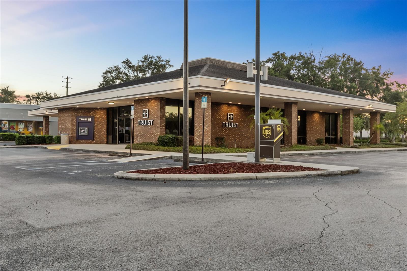 Situated at a prime intersection in Lakeland, Florida, this Truist Bank benefits from a highly desirable location in one of Central Florida’s most vibrant markets. Built in 1991, the property is fully leased to Truist Bank (Fitch: A+). The absolute NNN lease features annual rent increases and includes six five-year renewal options. The tenant has already executed an early extension, with 3.3 years remaining on the lease term. Truist Bank is responsible for all on-site obligations, including roof and structure maintenance.
The site offers ample parking, mature landscaping, and a convenient four-lane drive-thru. It is positioned as an outparcel to the Publix-anchored Plantation Square shopping center and is adjacent to a newly renovated McDonald's.
Over the past two years, Lakeland has experienced significant growth, adding more residents than any other area in Florida, thanks to its strategic location between Tampa and Orlando along the Interstate 4 corridor. The Truist Bank is located just west of Interstate 4, providing excellent connectivity throughout Central Florida. This unique positioning has attracted major distribution and logistics companies such as Amazon, IKEA, UPS, Rooms to Go, and Publix Supermarkets. Ongoing industrial development along the Interstate 4 corridor is expected to further reinforce Lakeland’s status as a key distribution hub in the region.
