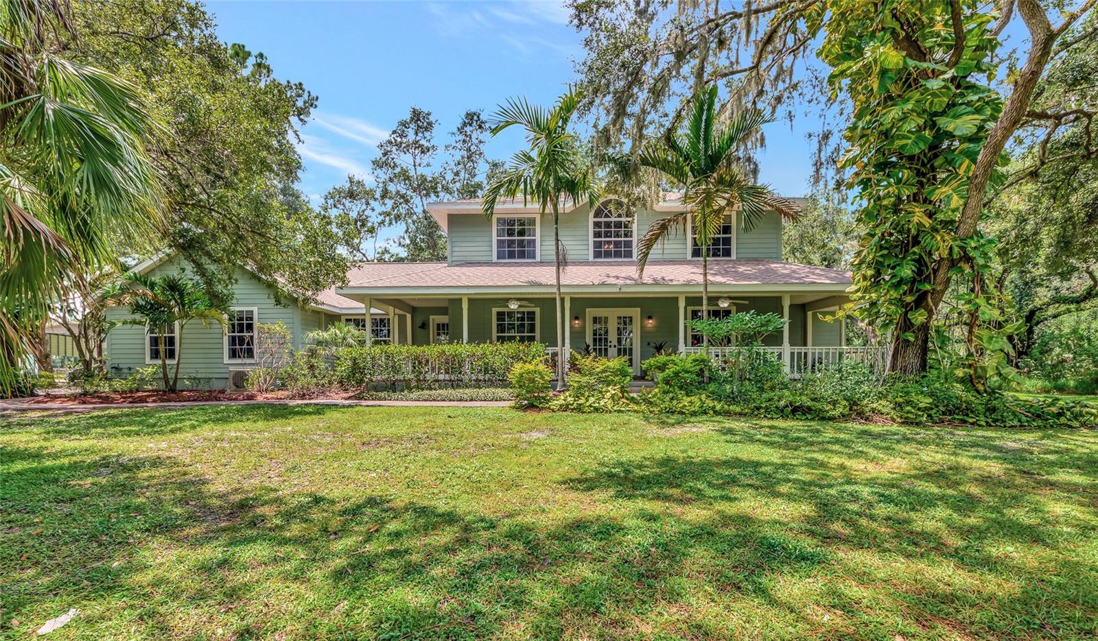 Rare equestrian oasis just minutes from Lakewood Ranch! Saddle up for the perfect blend of horse country serenity and suburban convenience. This one of a kind 5-acre equestrian estate is the closest acreage property to Lakewood Ranch, offering the freedom to live your riding lifestyle without sacrificing access to top tier shopping, dining, and entertainment. Tucked beneath a canopy of 100+ year-old grandfather oaks, this 4 bedroom, 3 bath, dual office (one could be a 5th bedroom) home spans over 3,104 sq ft and includes dual home offices (or a 5th bedroom) ideal for multi use living and remote work with room to roam. A private asphalt driveway leads you through lush, shaded pastures, setting the tone for the tranquil country setting that awaits. Inside, enjoy bamboo flooring downstairs and tile upstairs. The heart of the home is a renovated 2020 kitchen that features custom hardwood cabinets, granite countertops, and stainless steel appliances, perfect for hosting after a long day in the saddle. Step outside into a true outdoor retreat, where a freeform pool, covered outdoor kitchen, paver patio, Sonos surround sound, lighting, and fire pit come together to create a dream space for both relaxation and celebration. Horse enthusiasts will be drawn to the 30’ x 30’ center-aisle barn with 4 stalls and tack room thoughtfully positioned for convenience and comfort. The rear of the property is fully fenced and includes a professional-grade round pen, lush grazing pastures, and oak-shaded paddocks that have natural cooling and beauty. A scenic pond adds to the peaceful atmosphere, and there’s a separate RV/boat metal-framed structure with a metal roof ideal for horse trailers, boat, RV or farm equipment. Whether you’re training, trail riding, or simply enjoying morning coffee while your horses graze, this property brings the dream of equestrian living to life without the long commute. Schedule your private tour today and experience the rare luxury of living where you ride.