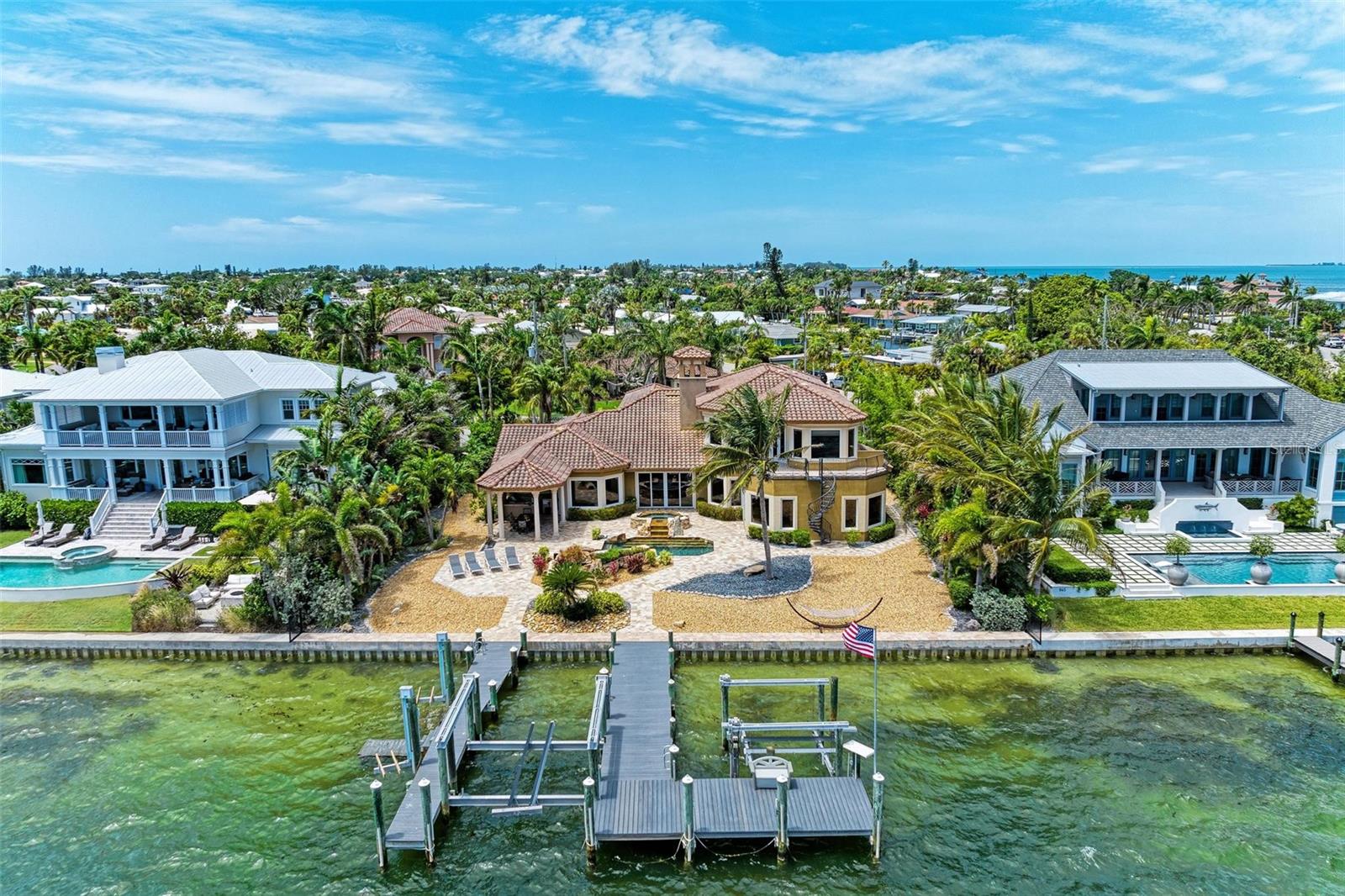 Spectacular custom home with huge Tampa Bay views on Anna Maria Island. This massive waterfront retreat boasts over 5,000 square feet under air and features luxury amenities throughout. Enjoy expansive water views from almost every room in this palatial island escape. The upstairs master retreat features a wraparound balcony with a separate staircase to the pool area, a coffee bar, walk-in closet, jacuzzi tub, double shower, and a separate office. The downstairs master bedroom has a private sitting room, ensuite bathroom and direct access to the outdoor kitchen, pool and spa. The oversized great room, separate living room with wood burning fireplace, and formal dining room make this a perfect home for large families to gather together. Boaters will love the two separate docks with an 18,000 pound lift and 2 jet ski lifts. Deep water with no bridges provide easy access to the Tampa Bay and the Gulf of Mexico. Please watch the virtual tour video and schedule your private tour today.