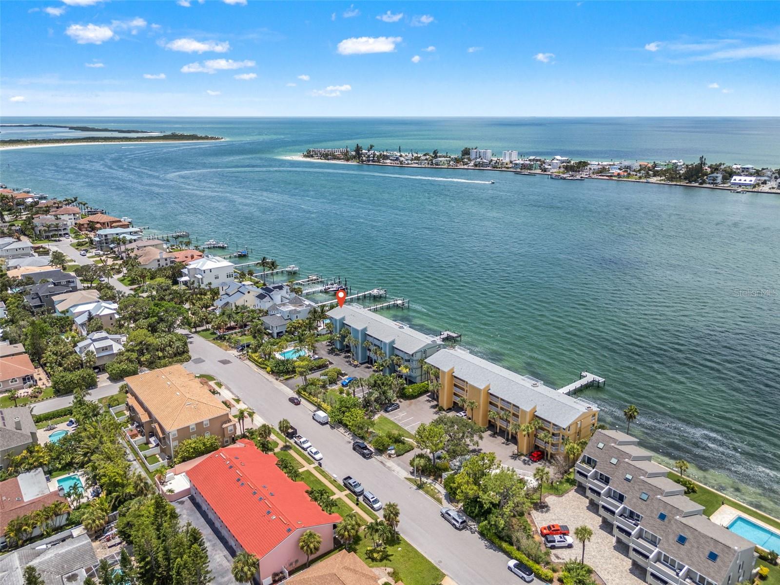 Stunning CORNER WATERFRONT condo with PANORAMIC views of Pass-a-Grille Channel in the exclusive 9-unit Flamingo Bay Club, Tierra Verde. Here, breathtaking sunsets and an abundance of marine life become part of your everyday experience. This exceptional condo has been completely renovated with impeccable attention to detail. This 2-bedroom, 2-bath residence features 180-degree water views, HURRICANE IMPACT WINDOWS, and elegant Spanish porcelain tile throughout. The open floor plan includes a spacious living room with wood-burning fireplace, chef’s kitchen with quartz countertops, custom wood cabinetry, stainless steel appliances, an induction cooktop and custom LED lighting. The primary suite offers balcony access, custom walk-in closet, and a spa-style ensuite with dual vanities and walk-in rain shower.
Enjoy breathtaking sunsets and views of Shell Key, Pass-a-Grille Beach, and the iconic Don CeSar Hotel from the expansive 50’ x 8’ balcony. Additional highlights include an oversized 1-car garage, two extra parking spaces, a private dock with kayak lift, a tropically landscaped pool, and recent community upgrades include a NEW SEAWALL and DOCK. Experience the best of Tierra Verde waterfront living — perfect as a full-time residence or coastal retreat.