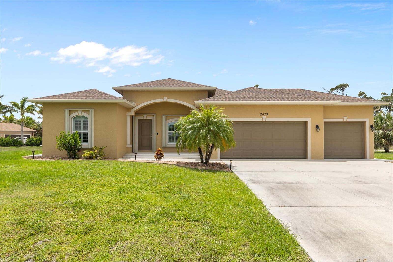 One or more photo(s) has been virtually staged. Welcome to 2479 Grandview Dr—where luxury, space, and peace of mind come together on a rare 1-acre corner lot that's not in a flood zone. Built in 2019, this 3-bedroom, 2-bathroom plus den home features a 3-car garage with epoxy floors, high ceilings, crown molding, tray ceilings, and plantation shutters. The home is outfitted with upgraded accordion hurricane shutters, a full security system, concrete sidewalks surrounding the entire property, and elegant plank tile flooring throughout. The spacious layout opens up to an expanded screened-in lanai—perfect for enjoying Florida’s indoor-outdoor lifestyle in privacy and comfort. With a full acre of land, there’s ample room to add a large pool, detached garage, or create your own private oasis.
Located in the growing city of North Port, you’re minutes from natural treasures like Warm Mineral Springs, the Myakkahatchee Creek Environmental Park, and over 95 miles of canals for kayaking and fishing. Families enjoy the North Port Aquatic Center and Atwater Community Park, while sports lovers appreciate being close to CoolToday Park, the spring training home of the Atlanta Braves. The city is also home to vibrant community events, art centers, walking trails, and just a short drive from Wellen Park’s waterfront dining and shopping district, plus multiple Gulf Coast beaches. Experience the best of Florida living in a home that checks every box.