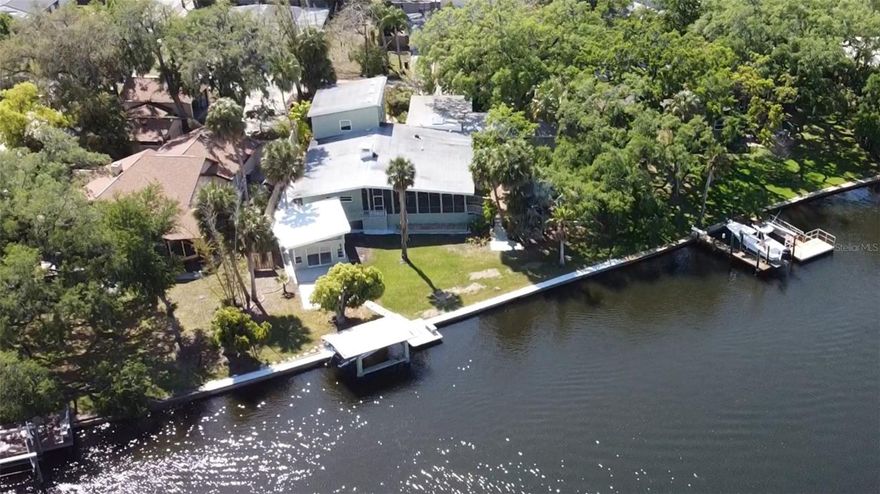 A RARE and irreplaceable MID-CENTURY MODERN FLORIDA WATERFRONT ESTATE offering approximately 155’ of water frontage delivering the kind of FLORIDA WATERFRONT LIFESTYLE that buyers search for & almost never find! 



Sitting on an expansive lot, this home sits HIGH & DRY (home has never flooded!) Surrounded by mature landscaping, this one-of-a-kind property blends TIMELESS ARCHITECTURAL CHARACTER, major system upgrades & unmatched versatility across multiple structures - creating a true live/work/play WATERFRONT COMPOUND.



Wake up to breathtaking EASTERN SUNRISE VIEWS pouring through an entire wall of glass doors overlooking the water. Enjoy daily encounters with dolphins, manatees, birds & passing boats - all from your own backyard. This isn’t just a home - THIS IS A LIFESTYLE.



MID-CENTURY CHARACTER + FUNCTIONAL DESIGN: This CONCRTETE FORTRESS made of exterior block/stucco, 4-bed, 4-bath home + dedicated office w/ built-in shelving offers a layout designed for flexibility and privacy. Home is 3,304 sq ft (heated) & 6,363 sq ft (total). Two primary suites w/ ensuite bathrooms on opposite sides of the home. Expansive mid-century modern living room featuring a statement stone wall fireplace & signature triangular windows. Ceramic tile flooring & retro terracotta/quarry tile mosaic flooring. Original mid-century tile bathrooms preserving authentic architectural charm. Custom built wood sauna with new heater. 9 closets (4 walk-in).  



The kitchen has been thoughtfully updated while maintaining its mid-century aesthetic: Custom handcrafted solid wood cabinetry & hardware. Granite countertops. Stainless steel appliances. Industrial sink, abundant cabinet space. Breakfast bar w/ picturesque window overlooking water views & tranquil rock garden.



UNMATCHED BONUS SPACES: This property offers an extraordinary amount of usable space beyond the main home: 1,536 sq ft detached two-story workshop/garage (768 sq ft downstairs + 768 sq ft upstairs) Upper level previously used as an art studio (w/ portable AC.) Ideal for conversion into a guest apartment, theater, home office, or studio. Separate concrete workshop overlooking the water. Perfect for entertaining: party pavilion, storage, or creative use. Covered carport + circular driveway for additional parking & accessibility.



This home has been significantly improved for long-term durability & efficiency: New service installed by Duke Energy. Whole-home surge protector. Emergency shutoffs (house & garage). Copper wiring throughout. GFCI outlets installed (2026). New AC unit (2024). Second AC system serviced/upgraded (2025). New whole-house manifold system. Updated plumbing to toilets. Solar water heater. Solar vent fan. Water softener. NEW Hurricane Impact windows. NEW interior & exterior Paint NEW Motion-sensor security lighting. 



This is not your typical waterfront home. This is a MID-CENTURY MODERN WATERFRONT COMPOUND with scale, flexibility, and character that is nearly impossible to replicate. Whether you're seeking: A primary residence, A multi-generational living setup, A live/work creative environment, Or a truly unique Florida waterfront lifestyle… This property delivers on every level.



Opportunities like this - a MCM Home and with this much waterfront, this much space, this much character & is IMMACULATE - do not come to market often. And when they do… they don’t last. Call today to schedule your private tour.