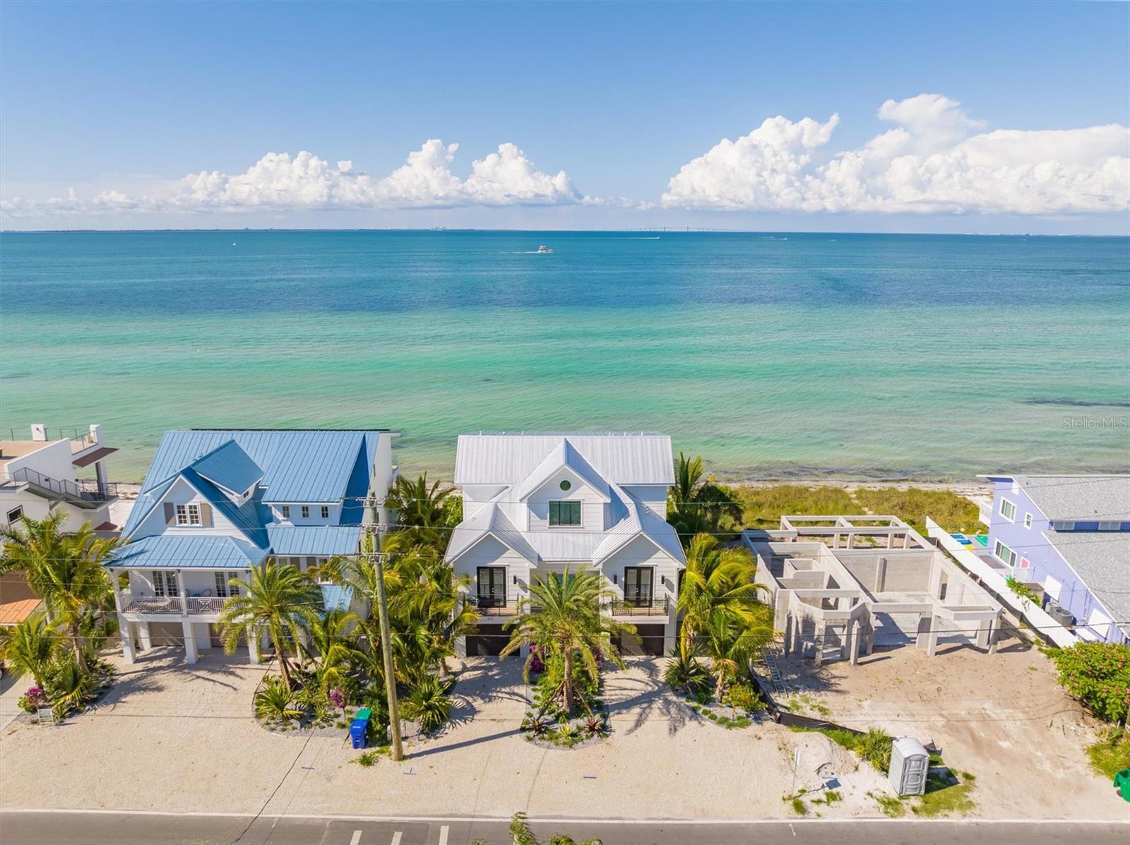 Completed in mid-2022 and built on an oversized 60’ wide lot, this Bayfront house in the North End of Anna Maria offers breathtaking, panoramic, open-water views . And unlike the Gulf, the sandy beach in front of this home is private! Only a few short blocks to the shops and restaurants on Pine Avenue, this professionally decorated island home features a large open-plan living area, 4 bedrooms each with an ensuite bathroom, half-bath, a separate living/sitting room on the top floor and extensive balconies overlooking the bay. This waterfront retreat is built to the highest standards and offers impeccable finishes throughout, including elevator to all floors, extensive trim-work throughout, solar panels, gourmet kitchen, and deep footer pilings. The gourmet kitchen showcases custom cabinetry, quartz counter tops, gas range, and high end appliances (Wolf, Subzero, Bosch). Built to minimize on-going costs thanks to roof-top solar panels, two efficient Daikin AC units, multi-panel impact-resistant windows and sliders, Florida-friendly irrigated landscaping, tankless water heater, and extensive insulation throughout. Technology features include multi-level Wifi hotspots, zoned Sonos sound system, Ring doorbell, security camera system and an in-wall iPad control station, thereby allowing you to remotely control your cameras, sounds system, doorbell, garage doors and thermostats using any smart phone/device. On the ground floor, you'll enjoy your very own tropical paradise featuring an indoor bar and game room area which leads outside to your large heated pool/spa, lush landscaping and miniature golf course, all overlooking the beautiful waters of Tampa Bay and your private sandy beach. The master suite has its own private balcony with nothing but water views and includes a huge bathroom with a walk-in shower and stand-alone soak-in tub. Don’t forget you can launch your kayak or paddle boards and toss a line and fish right in the bay waters, or simply relax by the pool listening to the waves!