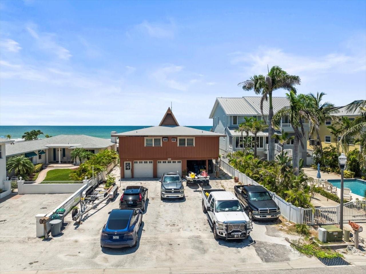 A rare opportunity has arrived in Redington Shores: a direct Gulf-front property offering unparalleled potential for both luxury living and lucrative investment. For the first time in over 30 years, this prime piece of real estate is available to the market. Currently zoned as a condo, the property has been cherished as a family vacation retreat, with two spacious units totaling 2,750 sq. ft. of living space—each featuring 3 bedrooms and 2 bathrooms. The existing structure boasts a large parking pad, two one-car garages, and under-building storage, adding functionality to its enviable beachfront location. There is over 50 feet of Gulf frontage and a Sea Wall Already in place and the City provides a Beach scraper to keep the beach front view clean and free of debris.
Another rare advantage: this property does not back up to Gulf Boulevard, providing a quieter, more private atmosphere with Constitution Park buffering the rear of the property, which has a dog walk, playground and town sponsored cookouts and events for residents. Just steps away, you’ll find the beach trolley, bus stops, local favorites like Candy Kitchen, Koko nuts Grill, Friendly Tavern, and Broke N Board, plus easy access to restaurants, coffee shops, and the famous Beach Pizza. The lot itself, just under a quarter acre (per attached survey), offers impressive development potential. The City of Redington Shores allows underground parking/storage and up to two floors of buildable space, with the potential for a third floor with variance approval.
The possibilities are endless: design a spectacular 2,500+ sq. ft. Gulf-front penthouse for your own use while generating income from luxury rental units below, or create a boutique Gulf-front development perfectly tailored for today’s high-end buyers and investors. Possibly two smaller buildings with a variance? All this, while being only 30 minutes to Tampa—home of the Buccaneers, Tampa Bay Lightning, the Rays, fine dining, international shopping, Broadway-caliber theater, and an international airport. Just minutes away, St. Pete offers a vibrant nightlife and its iconic new pier, while Clearwater Beach adds yet another world-class destination to the mix.