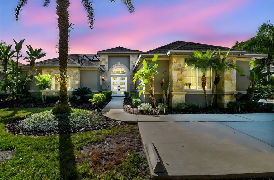 Welcome to this custom built home sitting on a gorgeous half acre lakefront lot. This home features a power entry gate, 5 full bedrooms assures that everyone will have their own private oasis overlooking either the pool or the lake, and each room will have it's own balcony or patio. There is also a separate in-law suite perfect for aging parents or teenagers wanting their own space, in law suite is poolside.  From the minute you enter the pool courtyard through the front door you will be amazed at everything this home has to offer. The living room with its gorgeous built ins, and fireplace, kitchen, and dining room all have stunning views of the pool. Kitchen features newer appliances, gas/propane stove, granite countertops with an island and two sinks not to mention a raised bar.  Kitchen also features a large walk in pantry.   The separate open dining area leads to the huge family/entertainment room with soaring 18 foot ceilings.  The entertainment room features lots of windows with fantastic views of the lake.  You'll also have a built in fireplace with an elevator tv that doubles as a security monitor.  On another wall you'll have a hidden power projector screen for a short-throw projector, giving you spectacular movie nights at home.   The unique shaped office-studio with high ceiling will give you plenty of controlled outside lighting with the built in window shutters and views of the pool/courtyard/front door.  the primary suite has high, coffered ceiling, two walk in closets, travertine throughout with built in cabinetry.  The huge screened enclosed back/lake patio gives you spectacular views of the large backyard and lake.  Pet friendly with a fenced side yard. Plenty of room on the patio for a portable firepit to enjoy the stunning sunsets over the lake.   The second story offers 3 bedrooms, two have their own balcony, on full bathroom and all new carpeting in 2025.  Oversized three car garage with durable flooring, insulated attic storage 2 transfer boxes for back up power hook up.  Garage is also wired for charging to EVs. Lawn sprinklers on a well.  All 3 hvac units replaced in 2017/2018, Pool remodeled and resurfaced in 2023, New roof in 2021, water heater replaced in 2020.  Tall 8 foot doors throughout.