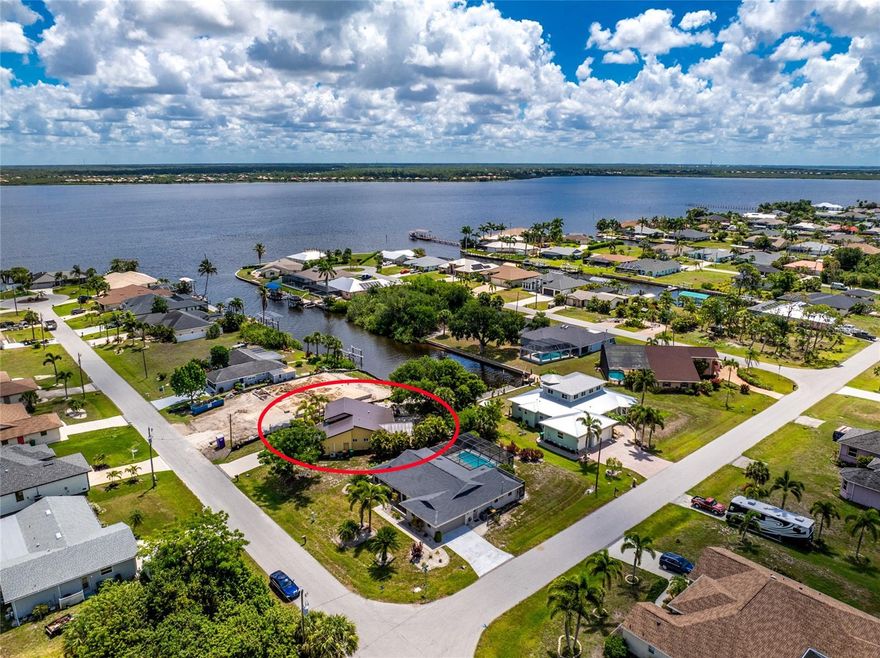 Peaceful canal living, glowing sunset skies, summer rainbows, and effortless boating access to the Myakka River and the Gulf beyond create a lifestyle that feels like a hidden Florida retreat. This move-in ready concrete block waterfront home offers impact windows, a 2023 metal roof, blown-in attic insulation, newer interior and exterior paint, designer light fixtures, and the option to purchase furnished for added convenience. Charming curb appeal welcomes you with an extra-large driveway and walkway leading to an oversized screened porch with newer double front doors. Mature landscaping, lemon trees, orange trees, dragon fruit plantings, and areca palm hedges are scattered throughout the property, adding tropical character and privacy. Originally designed for an artist, the home was positioned true north on the lot to maximize natural light throughout the day and create a unique living environment. Inside, the great room features soaring vaulted ceilings, a bay-style wall with a large window, and wood-look ceramic tile flooring throughout. The kitchen has both function and entertaining in mind, offering stainless steel appliances, granite countertops, rich cherry wood cabinetry with slow-close features, tile backsplash, pantry storage, built-in microwave, and an oversized island with breakfast bar seating, a cooktop with overhead hood vent, and cabinetry on both sides providing exceptional prep space and storage. The spacious primary suite offers tall ceilings, a large bank of windows allowing abundant natural light, a walk-in closet, and en-suite bathroom with granite countertops, cherry cabinetry with slow-close features, single vanity, and walk-in shower. The guest suite offers a reach-in closet, sliding glass doors leading to the lanai, and a bathroom with granite countertops, single vanity, tub and shower combination, pocket door, and matching cherry cabinetry with slow-close features. The attached garage includes its own mini-split air conditioning system, 50 amp RV outlet, and epoxy flooring, creating a comfortable and versatile space for projects, storage, hobbies, or additional workspace needs. Outdoor living continues with a spacious screened lanai overlooking the canal, while the open-air concrete patio offers space for a future outdoor kitchen or spa. A mature oak tree in the backyard creates a shaded space to relax or cast a fishing line. At the canal you'll find a concrete seawall, private dock with fish cleaning station, and 8,000-pound remote-controlled boat lift already in place, making it easy to cruise the Myakka River toward Charlotte Harbor and Gulf waters for fishing, waterfront dining, or afternoons anchored at nearby sandbars enjoying the saltwater. Gulf Cove offers a voluntary HOA with a low annual fee, community parks, playgrounds, pavilions, riverfront seating, and the option for private boat ramp access. Restaurants, shopping, medical facilities, golf courses, nature parks, and two Major League Baseball spring training stadiums are nearby. Come experience life at 2532 Dixon Terrace, where boating, fishing, and waterfront living become part of everyday life.