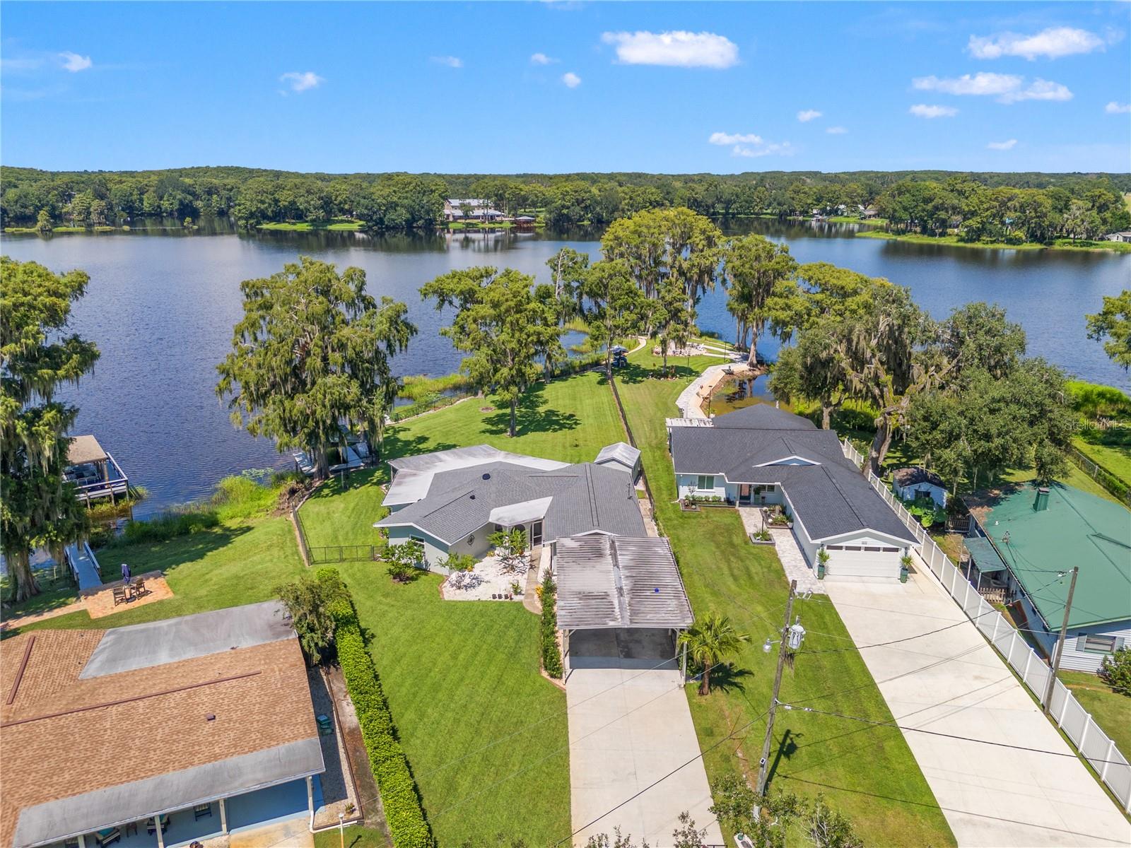 Tucked away in a quiet neighborhood, this lakefront home offers stunning water views on three sides and the serenity of true country living. Situated on a natural chain of lakes with no flooding issues, this property is surrounded by beautiful cypress forests and offers some of the best freshwater fishing in the area. Recent upgrades include new windows, a new roof (2021), new driveway, a new irrigation system, a resurfaced boat dock, and a new shower in the master bathroom. In addition to the central heat pump system, the home features four new mini-split units — one in each bedroom, one in the dining room, and one in the office — allowing you to keep individual rooms as cool or warm as you like without the expense of running the entire system. The home is connected to public water and high-speed internet, giving you the best of modern convenience in a peaceful, natural setting. Located just 5 miles from Inverness with only one traffic light, and 12 scenic miles to I-75 with no traffic lights, this property strikes the perfect balance of privacy and accessibility. Every bedroom and the main living spaces enjoy water views, and the peninsula setting makes this property truly one-of-a-kind. This is one of the best deals you will find in the entire state of Florida for lakefront homes, under $500,000. Come see it before it is gone.