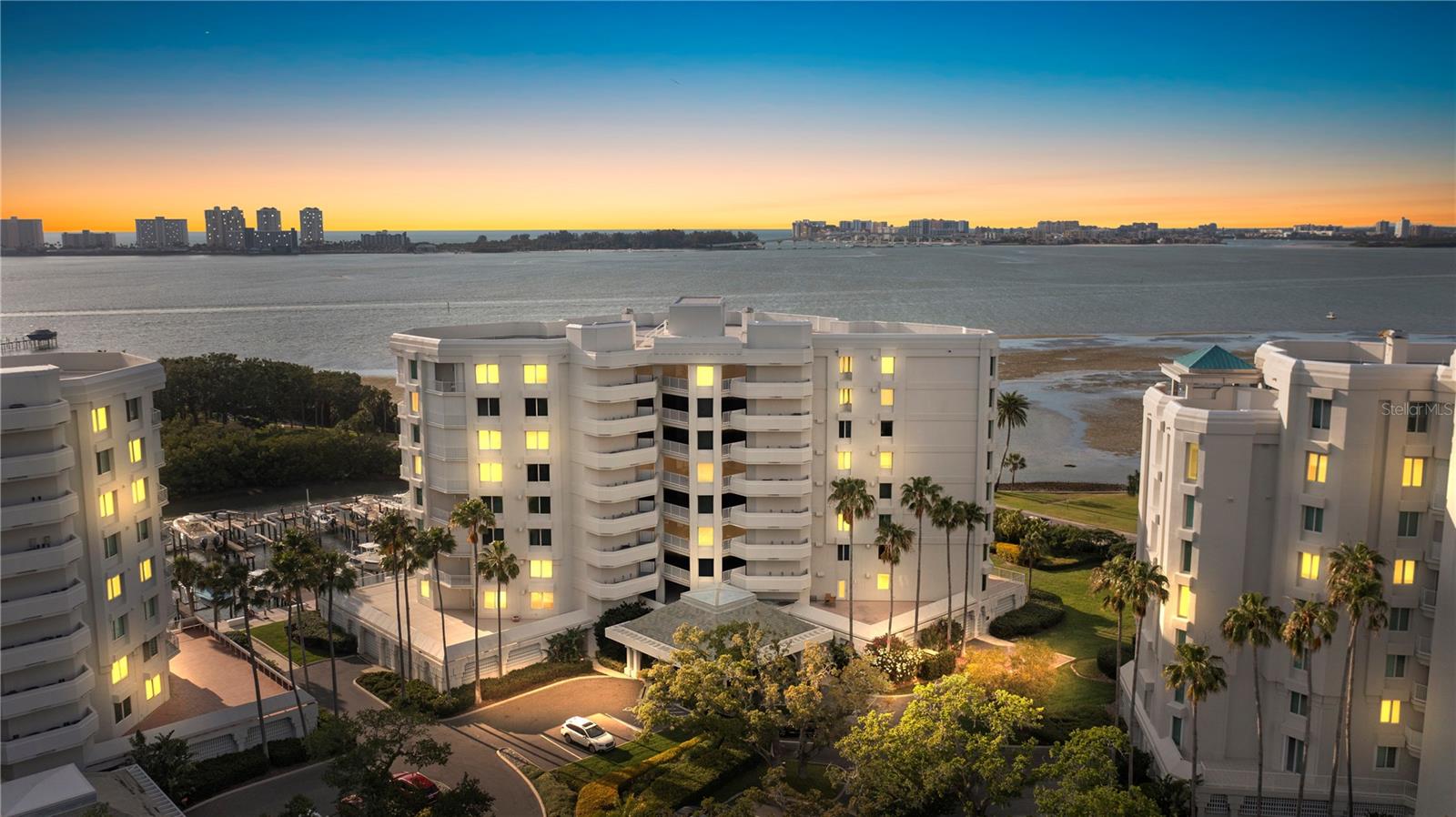 Introducing the exceptional waterfront penthouse, perched upon the pinnacle of the esteemed Seaside II in Belleair. Immerse yourself in the idyllic sunset views from the western-exposure balconies. Protected by Belleair Country Club's 24-hour manned gate, this secure community delights in a tranquil park-like setting embellished with magnificent trees, creating an awe-inspiring ambiance. Prepare to be enchanted as you step into this opulent top-floor penthouse, where dual balconies frame picturesque views of the Intercoastal waterway, Sand Key, Clearwater Beach, and the expansive Gulf of Mexico. From the moment you walk in, a breathtaking panoramic view greets you, complemented by a thoughtfully designed floor plan that encompasses a gracious two-wing split arrangement. No expense has been spared in the creation of this extraordinary residence, evident in the meticulously crafted custom cabinetry and built-ins, the rich hardwood floors, opulent molding, and the state-of-the-art appliances. The generously proportioned bedrooms all boast walk-in closets. The penthouse has ample storage, elegant double-leaded glass entry doors, recessed lighting, and a cozy wood-burning fireplace that elevates the living experience. This home showcases impeccable attention to detail. This exclusive home epitomizes an upscale lifestyle. There are two allocated garage parking spaces beneath the building and two air-conditioned storage rooms housed in a separate structure on the manicured grounds. The building has its own private pool and hot tub as well. The views inside and outside will not disappoint.