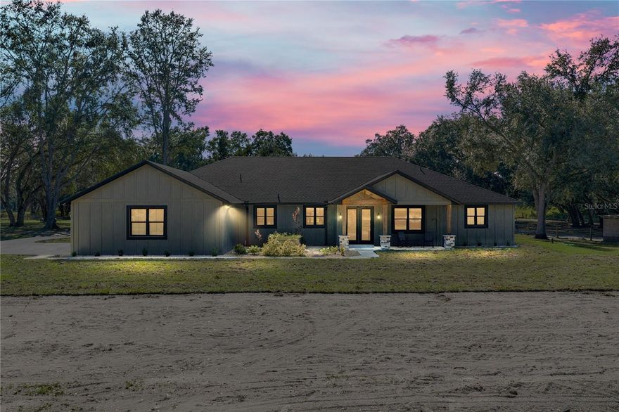 Two 2024-built homes, two outbuildings, and an unbeatable setting await on 10.19 fully fenced
acres. The 3,741 sq ft main residence and 1,204 sq ft guest home combine with their outdoor
spaces to create over 8,000 sq ft under roof, offering an expansive modern country estate like no
other. Nestled in a serene agricultural landscape, this substantial and stunning property
showcases top notch materials, expert craftsmanship, and a level of versatility rarely seen in rural

luxury properties. Mature trees frame the entrance, introducing a setting designed for multi-
generational living and refined country living. The main home features 4 bedrooms + office, 4.5

bathrooms, and a 3 car garage. Inside, a sprawling open concept layout is highlighted by soaring
vaulted ceilings, pine accents, wood look luxury vinyl flooring, and a stone feature wall with an
elegant electric fireplace. The kitchen is a masterpiece of modern farmhouse aesthetic, with two
toned cabinetry, a brick backsplash, stone countertops, a custom range hood, a hidden walk-in
pantry, a farmhouse sink, and a central island with breakfast bar seating and lighting that
perfectly suits the space. A full size dining area opens seamlessly to the living room and kitchen
for an inviting entertainment experience. The office sits behind vintage wood doors, and a nearby
laundry room with a dog wash station adds everyday convenience for chores and work alike. A
second living room and guest half bath expand the home's functionality even further. Each
bedroom includes its own walk-in closet with custom wood organizers and ensuite bathroom, a
feature homeowners crave. The primary suite takes luxury to another level with more than
$65,000 invested in its private retreat. The ensuite features a walk-through custom tiled and
glassed shower, a soaking tub, dual sinks with vanity seating, and a stunning white oak custom
closet with a central island, chandelier, and extensive built-ins. The covered back porch offers
tranquil views and is already plumbed for an outdoor kitchen. Icynene insulation and PGT
windows add energy efficiency throughout. Across the property, the second residence provides a
peaceful haven with 2 bedrooms, 2 bathrooms, a 3 car attached carport, and covered front and
rear porches accented by cypress beams. High ceilings and an airy open layout complement an
inviting kitchen featuring a sycamore topped island, a coffee bar, stainless steel appliances, a
custom range hood, and easy access to the laundry room. The split bedroom design maintains
privacy, and both bathrooms are beautifully finished with a mix of walk-in showers and soaking
tubs. The massive temperature controlled 2 bay garage offers 10 foot doors, built-in cabinets,
multiple work benches, and exceptional storage capacity. A 5 bay detached carport includes
enclosed climate controlled storage and a half bathroom. Fenced Animal pastures make this a
dream for those with livestock or pets! Every feature of this estate reflects quality, thoughtful
design, and hard-to-find flexibility. Opportunities like this are rare in today’s market. Schedule
your private showing and experience it for yourself today!