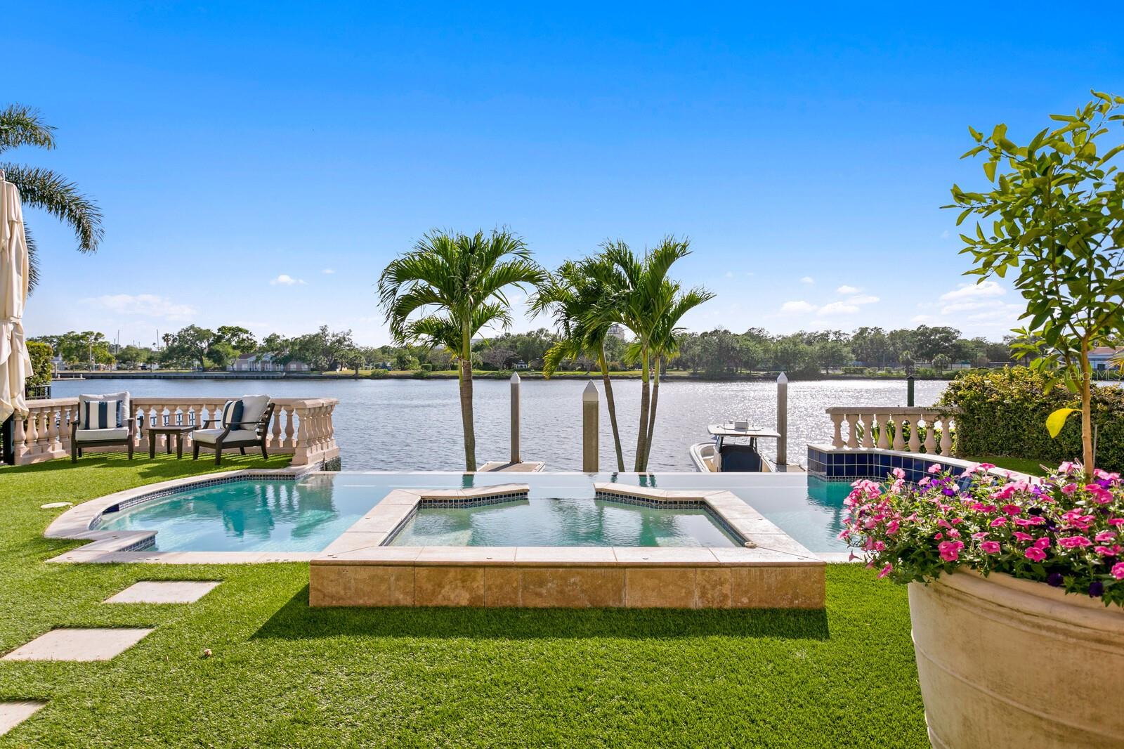 Under contract-accepting backup offers. FULLY RENOVATED HARBOUR ISLAND WATERFRONT SINGLE FAMILY HOME WITH YACHT DOCKAGE. Welcome to this masterfully renovated Harbour Island estate representing the finest in luxurious living and refined sophistication. Located in this guard-gated waterfront enclave, Modern Mediterranean architecture and a tranquil courtyard lends an ambiance of warmth to sleek interior spaces boasting soaring ceilings, professionally curated finishes and state-of-the-art design. An extensive $2.0m, down to the studs renovation blends interior high style with rarely found 2 deep water boat slips available for yacht dockage . An elegant courtyard fountain and impressive impact-glass double door entry welcome you to spectacular waterfront living in this Island paradise. The transitional design offers an elegant, suspended stairway that descends to the flowing living spaces, stunning hardwood floors, floor-to-ceiling windows/doors and water views beyond. Grand living on the first level includes numerous areas for entertaining -- a living room with remote-gas fireplace, formal dining room, family room with coffered ceiling and custom cabinetry, along with a lounge area and premier entertaining bar with dual Sub-Zero wine refrigerators. In the center of it all is a dream kitchen to please the most discerning chef. An expansive custom island and marble countertop/backsplash is only the beginning. Premium Wolf, Sub-Zero and Bosch appliances, professional-grade gas range, and beverage refrigerators are complemented by an inviting dining area that delivers a spectacular water view sunrise to sunset. Retracting glass doors open to a personal oasis with a covered lanai, waterfront infinity edge pool, spa, and low-maintenance turf lawn with terraced seating. A spacious in-law/au-pair casita provides a first level living room and kitchenette with private courtyard entry, a second level bedroom with en-suite bath, and sitting room with balcony accessed by a secondary spiral staircase. The second level primary suite is tucked into a private wing of the home and delivers pure decadence with a sitting area and wood-burning fireplace, beverage station wet bar and retracting doors to a sweeping waterfront terrace. Opulence is found in a large waterfront custom closet, 2 additional closets, and the marble-clad primary bath offering a custom MTI deep soaking tub and Kohler steam shower. The remaining private spaces of the home are found on the second level and include 3 gracious guest bedrooms, 2 full baths and a laundry room. Additional appointments include upgraded systems (electrical, plumbing, HVAC), impact doors/windows, custom hardwood and marble flooring, custom cabinetry, smart home controls that include Lutron lighting and motorized shade systems, custom Restoration Hardware fixtures, California Closets throughout, exterior gas lanterns, 2-car garage with 4 car capacity with included hydraulic lifts, tankless water heater system with whole-house water filtration, and a brand new (2025) concrete tiled roof. Harbour Island is a private, guard-gated community set in the heart of Tampa, offering around-the-clock security and a prime urban location. Just outside the neighborhood, residents have walkable access to some of the city’s most popular attractions including the Riverwalk, Water Street, Amalie Arena. The island itself features green spaces, playground, and marina facilities. Available fully furnished at additional cost.