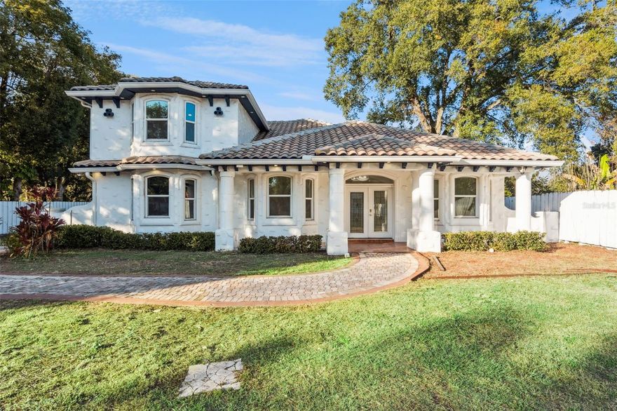 Step into elegance with this extraordinary Mediterranean-inspired estate, a custom-built two-story residence that effortlessly blends classic design with modern comfort. Set on an expansive 2/3-acre homesite with no HOA, this stunning 4-bedroom, 4-bath home offers exceptional privacy, space, and refined living. A grand gated entrance with a stately 9-foot wall leads to the beautifully maintained 3,784-square-foot residence, complete with a durable tile roof and a spacious three-car garage designed for convenience and storage.  The meticulously landscaped grounds feature a paver driveway with abundant parking, easily accommodating boats, RVs, trailers, and guests. Inside, architectural details abound, including soaring ceilings, crown molding, decorative columns, statement lighting, custom built-ins, and a wood-burning fireplace. The desirable split-bedroom floor plan enhances privacy, with three bedrooms offering en-suite bathrooms.  The primary suite is a true sanctuary, showcasing elegant tray ceilings, an impressive 35' x 12' walk-in closet, and a spa-inspired bathroom adorned with floor-to-ceiling travertine tile. The recently updated kitchen is both stylish and functional, featuring 42-inch cabinetry, quartz countertops, stainless steel appliances, double wall ovens, new flooring, and updated lighting—perfect for everyday living and entertaining alike.  The fourth bedroom, located on the second level, offers added flexibility with dual closets and its own dedicated central A/C system, making it ideal for guests, extended family, or a private office. Outdoor living is equally exceptional, with a spacious paver patio designed for entertaining, complete with a custom fire pit and fire bench that create a warm, inviting setting for year-round gatherings.  Ideally located just minutes from downtown Ocoee, Winter Garden, and Orlando, this home provides easy access to Highways 408, 429, and the Florida Turnpike. Enjoy nearby community events, farmers markets, dining, shopping, and Central Florida’s world-class attractions. Offering a rare combination of luxury, land, and location, this remarkable property is a standout opportunity in one of Ocoee’s most desirable areas. Schedule your private showing today to experience it firsthand.