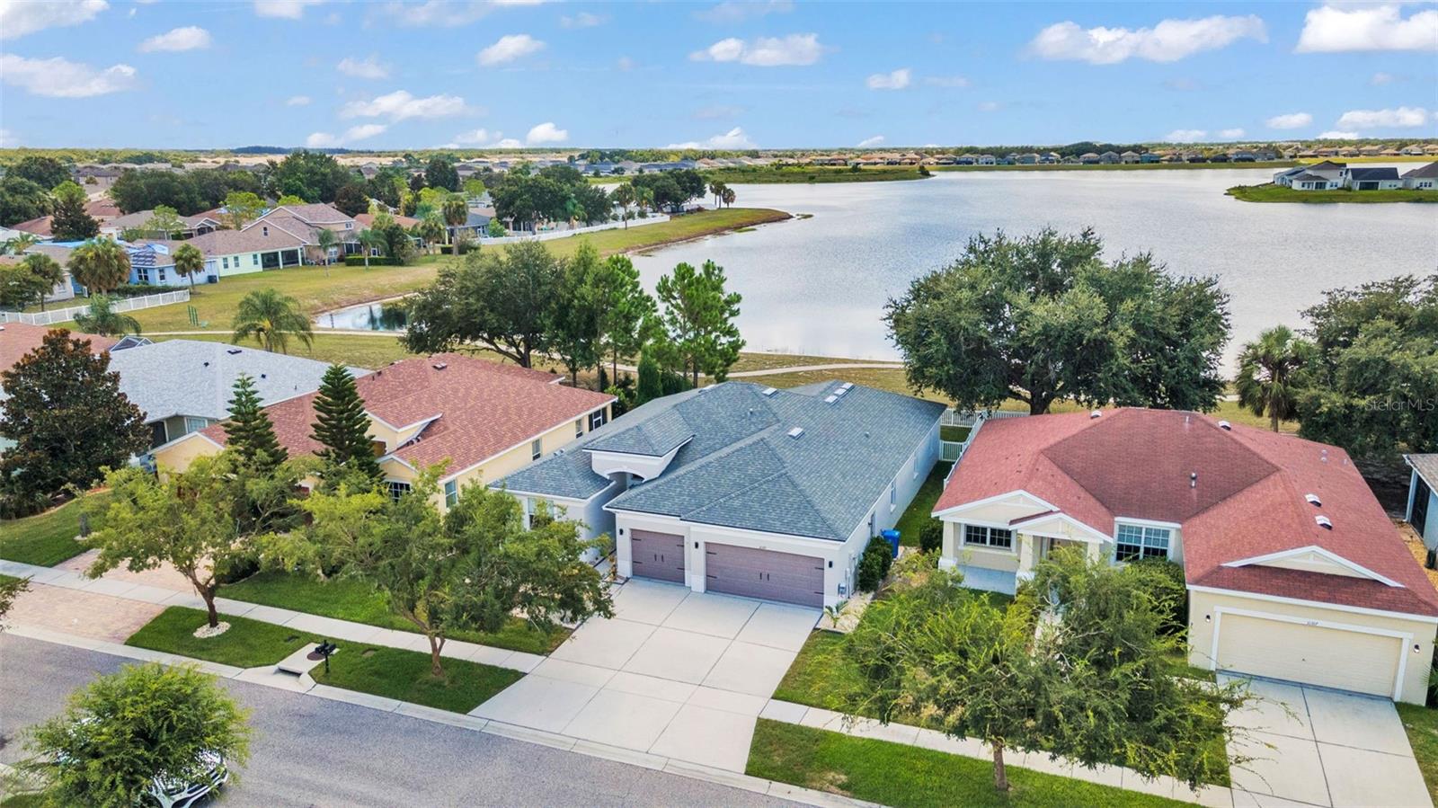 WATERFRONT – Great 80+ Acre lake in the community of Rivercrest!! A gorgeous 4-bedroom, 3-bath, 3-car garage home with a completely fenced yard! Light and bright featuring an open floor plan, ceramic tile throughout, and stunning lake views from almost every room. The spacious formal living and dining room combo greets you at the entry, with sliding glass doors leading to a covered, screened lanai overlooking the lake. The private owner’s retreat offers two closets and an en-suite with dual vanities, a garden tub, and a separate shower. Three additional bedrooms and two full baths are tucked away on the opposite side of the home. The kitchen boasts granite countertops, 42" cabinetry, and ample storage, stainless steel appliances, flowing seamlessly into the family room. Enjoy the screened lanai or sit by the firepit to enjoy your lakefront views. Recent updates include a new roof (2021) and A/C (2023). Enjoy access to two community pools, a thrilling water park for the family, and a vibrant play area, professional basketball and tennis courts. The community also features a recreation center, scenic walking trails, an athletic field, and a tot lot—perfect for family fun and outdoor activities. Conveniently located to I-75 and easily accessible to MacDill AFB, Shopping, Dining, Beaches, South Tampa and Sarasota!