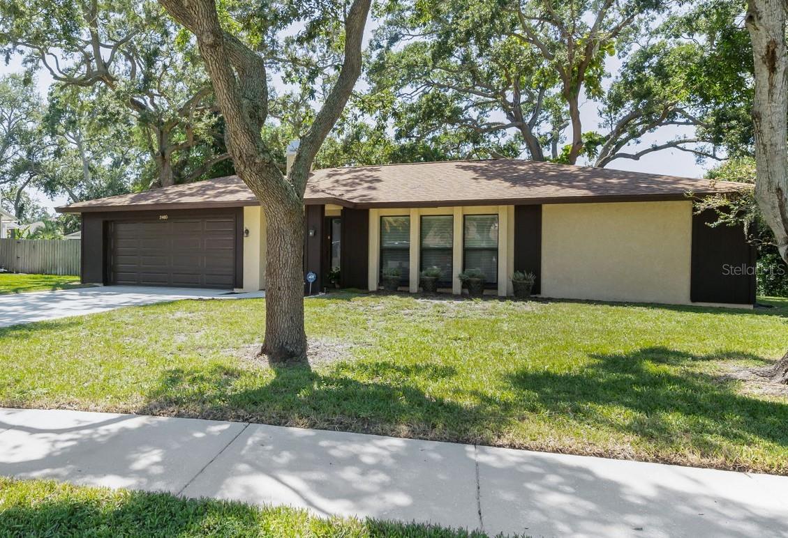 One or more photo(s) has been virtually staged. Located in the sought-after city of Dunedin, this one-owner home is situated in a peaceful, lovely neighborhood within minutes of charming downtown restaurants, breweries and many year-round activities. PRICED BELOW APPRAISED VALUE, this 4BR/2BA ranch home has a 1/3 acre lot, split bedroom plan, PGT impact interior windows (all but one) in a non-flood zone. The best part: all the big-ticket items have already been done: new roof (2020), new AC (2023), garage door (2021), hot water heater (2019). As you enter, you'll notice the spacious living/dining room area, perfect for entertaining. All four bedrooms are good size. The primary suite includes an updated (2018) ensuite bathroom (granite counters, newer vanity & tile, lighting) and a walk-in closet. The three secondary bedrooms (one of which can be used as an office) are located on the opposite side of the home, each with ample closet space and convenient access to the 2nd bathroom. The kitchen is adjacent to the family room and has Corian counters, wood cabinets, stainless steel appliances and a breakfast bar. Sliding doors from three rooms open to a huge porch/sunroom - a relaxing retreat overlooking the yard and patio. Hurricane shutters for the porch are included in the sale. Conveniently located close to everything: shopping & mall, medical facilities, downtown Dunedin, the Pinellas Trail, TD Ballpark, scenic parks and the beautiful gulf beaches at Honeymoon & Caladesi Islands and Clearwater Beach. Tampa International Airport is a short commute away. Don't miss this opportunity to make this house your own in one of Florida's most desirable communities!