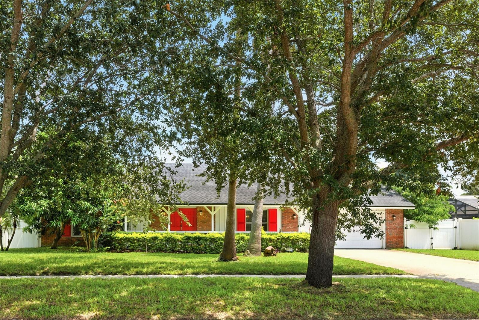 Discover Hidden Springs, an established community in the heart of Dr. Phillips and surrounded by incredible amenities within arm’s reach. This 3-bedroom 2 bath split plan pool home, is freshly renovated and ready to move right in. An open concept living plan showcases large gathering space with kitchen, dining and living rooms that seamlessly blend and open out to covered porch for fantastic opportunities to entertain. Kitchen is light and bright with 42” white shaker cabinetry, lots of counter workspace, stainless appliances. The island takes center stage with counter seating with designer pendant fixtures above and skylight for natural light. Brand new laminate wood flooring throughout creates seamless design and a durable low maintenance surface. Gathering space surrounds fireplace that is flanked by veranda doors out to the screened pool and backyard. Split plan provides privacy, and primary suite is generous with walk in closet and sleek bathroom with stone appointments and more. Outside enjoy a covered porch and screened pool enclosure which keeps the outdoor entertaining area fresh to enjoy the best of Florida weather. Home has many upgrades that include recent updates roof (2018), water heater (2 years new), AC (@1 year new), Replumbed, updated electrical, pool heater (@3 years new), updated kitchen and baths, updated molding & fixtures, recessed lighting, fresh paint, fresh sod and more. Don't miss this unique opportunity to own a piece of this exceptional community. Schedule your private showing today and begin creating new memories. Just minutes from Orlando’s famed attractions, fine dining, upscale shopping, and world-class golf courses. Enjoy views of the nightly fireworks from the attractions, and take advantage of this distinguished location.