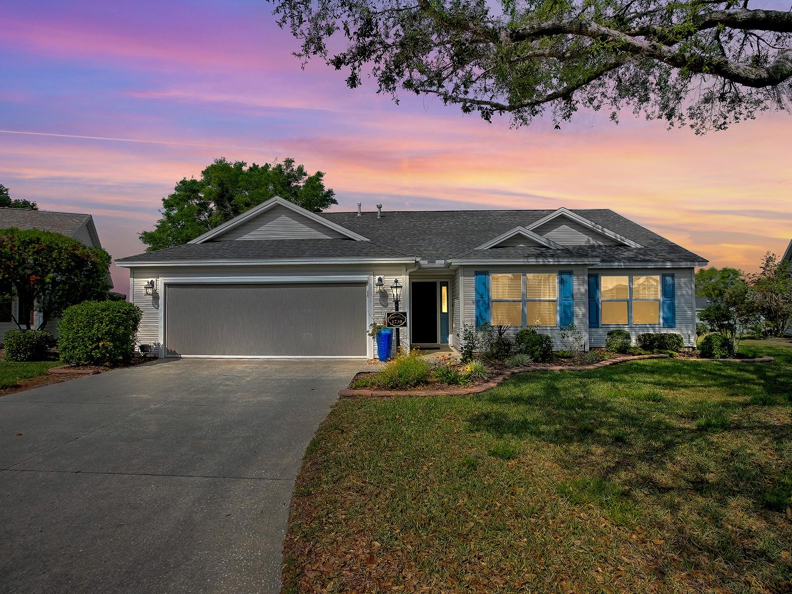 A panoramic golf course view and spectacular sunsets await you from the fabulous custom lanai of this designer home located on the first hole of Cane Garden’s Hibiscus championship golf course. Enjoy golf front living in the centrally located Village of Sunset Pointe while only a short drive to Lake Sumter Landing or Brownwood Town Square. The heart of this home is a gourmet chef’s dream kitchen complete with a stainless steel six-burner gas VIKING range, VIKING dishwasher and a built-in oven, as well as a French door stainless refrigerator, microwave and glass range hood. The expansive quartz counters provide plenty of prep area, and the oversized custom quartz island is sure to be a favorite gathering spot for friends and family. The open floor plan seamlessly flows from dining to living areas which is great for entertaining. Adjacent to the dining room is an optional 3rd bedroom currently used as a quiet and cozy den with custom French doors perfect for reading or relaxing. The primary bedroom features a beautiful board & batten statement wall, and comfortably accommodates a king size bed ensemble. The ensuite primary bath has a comfort-height vanity with dual sinks and a glass-enclosed step in shower – perfect for unwinding at the end of a busy day. Sliding patio doors lead from the living room to the awesome 24x20 (480 sq. ft.) screened lanai. Whether hosting a large party or just soaking in the serenity of a golf course & sunset view, this will instantly be your favorite place! Beyond the lanai the large yard offers plenty of space to enjoy the fabulous Florida sunshine – all in the privacy of your own backyard with NO houses behind. There’s even room for a pool. The oversize 2 car garage has built-in storage & pull-down stairs to the attic. The garage door has a remote-controlled screen allowing for comfortable use in all seasons. New roof (2022), and new A/C (2023). Bond balance is $5,716. This great location is only a short golf cart ride to Cane Garden Country Club, and the Hibiscus and Jacaranda championship golf courses. Also close by are the beautiful Pelican and Heron executive courses. Several rec centers are nearby, including the Sunset Pointe, Poinciana, Hibiscus, and Allamanda Neighborhood Rec Centers, as well as Lake Miona, Seabreeze, and Colony Cottage Regional Rec Centers. Abundant shopping and dining venues are available in several convenient locations easily accessible by golf cart or car. Call today to schedule your private showing.