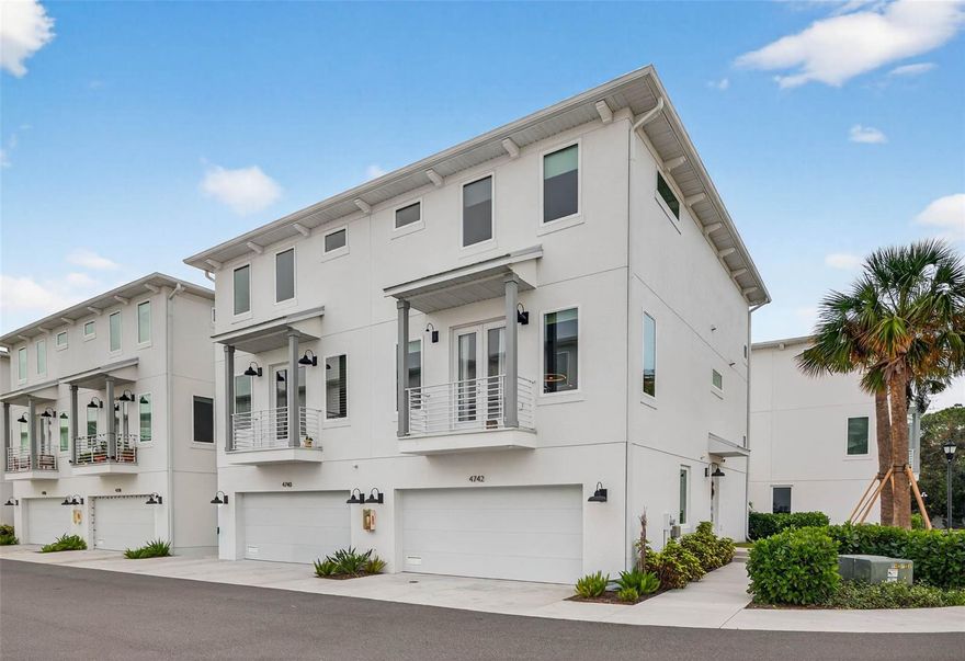 Set within the highly sought-after, private and gated Legacy Park community, this exceptional three-story townhome offers refined luxury, thoughtful design, and turnkey convenience. Featuring 3 bedrooms, 3.5 baths, and a 2-car garage, the residence is distinguished by three true ensuite bedrooms, providing rare privacy and flexibility. This newer-construction end unit is bathed in natural light and showcases high ceilings, impact-rated windows and doors, and luxury LVP and designer tile flooring throughout. A striking custom contemporary media accent wall with smart lighting, curated artwork sconces, and a Crate & Barrel chandelier create a sophisticated, modern aesthetic. The home may be offered fully furnished with Restoration Hardware and Crate & Barrel furnishings for a seamless, turnkey experience. The chef’s kitchen features two-tone soft-close shaker cabinetry, beveled tile backsplash, under-cabinet lighting, pantry built-ins, a deep commercial-grade sink, and a Whirlpool stainless steel appliance package. The oversized primary suite impresses with custom closet systems and a spa-inspired bath complete with a walk-in waterfall shower and a TOTO washlet. Designed for indoor-outdoor living, the home offers two private outdoor spaces, including a second-floor balcony and a first-floor deck off the ground-level ensuite. Additional highlights custom blinds throughout, an assumable flood policy, and transferrable warranties. The HOA provides a low-maintenance lifestyle with gated entry, pool, all exterior maintenance, water, sewer, and trash included. A rare offering in Legacy Park—where elevated design, privacy, and effortless living converge.