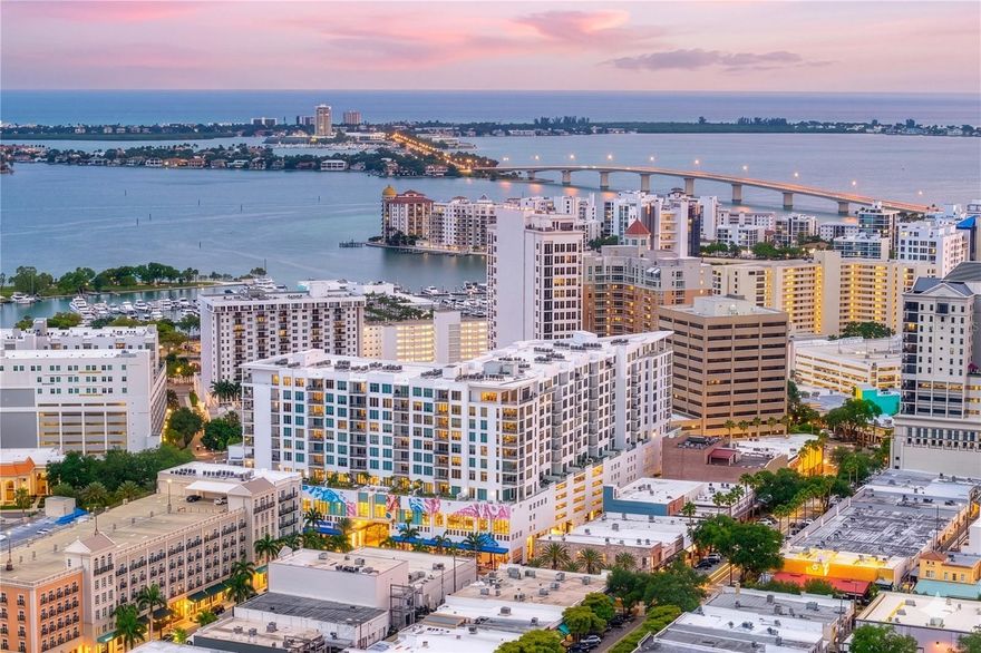 Experience elevated urban living in this spectacular penthouse residence at The Mark in the heart of downtown Sarasota, showcasing sweeping views of the city skyline, Sarasota Bay, and the Gulf of Mexico, this home blends sophisticated design with luxurious comfort. Thoughtful upgrades include custom lighting and automatic window shades throughout. Voluminous ceilings, 24" white porcelain floors and expansive windows create a bright and inviting atmosphere. The open-concept floor plan is designed for effortless entertaining, featuring a gourmet kitchen w/Jenn Aire appliances, spacious dining area, and elegant living room that opens to an oversized private terrace complete with a summer kitchen and electric grill. The primary suite offers two generous walk-in closets and a spa-inspired bath with a deep soaking tub, dual vanities, a glass-enclosed water closet, and a separate glass-enclosed shower. Both the primary and guest bedrooms enjoy water views. Two parking spaces within the private attached garage. The Mark offers exceptional amenities including 24-hour concierge service, state-of-the-art fitness center, resort style heated saltwater pool and spa, club room w/catering kitchen, fireplace, billiards and more. Located within close proximity to Whole Foods, Restaurants, cultural venues, art galleries and Bayfront Park.