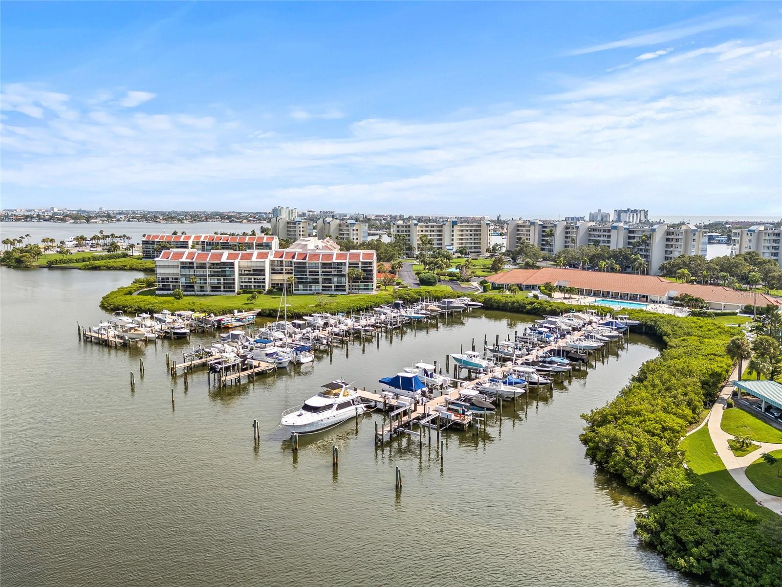 One or more photo(s) has been virtually staged. RENOVATED COASTAL CONDO WITH WRAPAROUND WATER VIEWS IN GATED COMMUNITY JUST MINUTES FROM ST PETE BEACH | Set within the gates of Sailboat Key, an exclusive resort-style condo community, this spacious corner-unit condominium offers 1,445 square feet of refined living space with two bedrooms, two bathrooms, and sweeping wraparound balcony views of the Intracoastal. Enjoy custom-curated designer details which include new cabinetry, countertops, fixtures, lighting, flooring and more.
The open-concept living and dining areas are anchored by new waterproof laminate flooring and incredible natural light streaming through sliding glass doors. The beautifully remodeled kitchen features Silestone countertops, oat-colored cabinetry with built-in under-cabinet lighting, and stainless steel appliances, creating a sophisticated yet welcoming space for cooking and entertaining. Both bathrooms showcase floating vanities for a sleek, modern touch, while the bedrooms feature custom built-in closet systems for effortless organization. The primary suite offers a spacious retreat with a walk-in closet, private balcony access, and an ensuite bathroom.
Additional highlights include hurricane shutters for peace of mind, in-unit laundry, assigned covered parking, and a balcony ideal for morning coffee or evening sunsets.
Life at Sailboat Key is resort-style and carefree. Residents enjoy 24-hour guard-gated security, a heated waterfront pool and spa, a fitness center, clubhouse, tennis courts, and social spaces. The community also offers marina access with a seawall and beautifully landscaped grounds.
Ideally located just minutes from St. Pete Beach, Treasure Island, and downtown St. Petersburg, this condominium offers the perfect blend of comfort, security, and waterfront living.