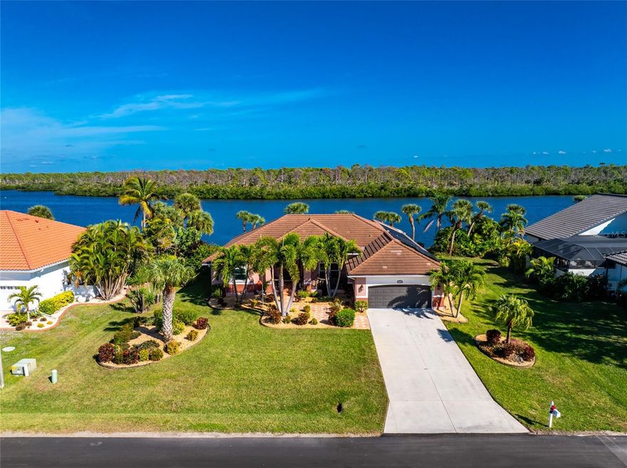 JUST - WOW!  What a spectacular panoramic view of Coral Creek, as soon as you enter! Coral Creek is one of the most pristine and natural bodies of water in this entire area! And it's not just about the view - This stunning spacious home is being sold FURNISHED (with just a couple of exceptions) so no need to spend $1000's more on furniture!  The open floor plan features a formal living and dining room, with sliding glass doors opening onto the lanai. The kitchen is a cook's delight, with plenty of cabinetry, granite countertops, and stunning backsplash. Appliances include: BRAND NEW French door refrigerator, microwave, smooth top stove, and dishwasher (all GE)  There's a pass through to the lanai, making entertaining a breeze! The butler's pantry provides all the storage you might need for your food items or your pots/pans/small appliances! The built in desk area w/tumbled marble backsplash is a great place to set up your laptop and printer, and perhaps a cookbook or two!  Dinette/breakfast nook is  handily located in between the kitchen and family room with sliding glass doors opening on to the lanai. Speaking of the family room, this is where you are sure to gather and watch a football game or movie! There's an electric fireplace for some extra ambiance, tray ceiling and a decorative bar! The primary bedroom features easy care laminate flooring, tray ceiling and ceiling fan, two walk in closets and another set of sliding glass doors to the lanai, providing a GREAT WATER VIEW, The Primary Bath has updated plank tiled flooring, updated vanity w/granite countertop and double basins, new mirrors, and COMPLETELY UPDATED ROMAN SHOWER. Guest bedrooms both have ample room so your guests won't feel crowded, plus ceiling fans and wall closets. Guest Bath has a combo tub/shower for those who enjoy a nice soak! Inside laundry houses the Samsung washer and dryer, Two car garage has pull down stairs, with access to the attic, and an automatic garage door opener. The lanai and pool area are the HIGHLIGHT of this home, with pavered decking and wrap around seating area. The beautiful solar HEATED pool has a sparkling pebbletec finish (done in about 2020) and the HUGE POOL CAGE WAS REPLACED IN 2023 - built strong to withstand wind! Tile Roof new in 2020, overhead garage door in 2020, and AC in 2018.  BEST OF ALL, THERE'S A PHOTOVOTAIC SOLAR SYSTEM FOR WHOLE HOUSE, saving you thousands on your electric bill. (Last month the seller's electric bill was less than $30!) IMPACT WINDOWS  provide peace of mind, and the StormSmart screens protect the lanai.  CORAL CREEK is perfect for kayaking, paddle boarding and shallow draft boating access on out to Lemon Bay and pristine beaches. Cape Haze Windward is a deed restricted subdivision, with an 18 hole golf course in its midst. Shopping is close by, and famous Boca Grande, known for it's tarpon fishing, white sandy beaches, and celebrity visitors are just minutes down the road and over the causeway.  There are numerous airports that provide fast and easy access, depending on where you are travelling from: Punta Gorda Airport (PGD), Sarasota International (SRQ), Fort Myers (RSW), and Tampa International Airport (TPA) are all within a reasonable drive. Homes with this natural scenic view don't come on the market very often, So don't delay!