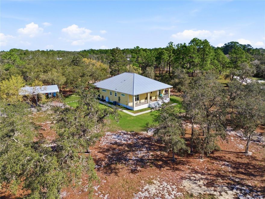 A True Escape Into Old Florida. Tucked deep within the gated wildlife sanctuary of Blue Jordan Forest, this remarkable 2.86-acre corner property offers a lifestyle that feels worlds away from the noise, pressure, and pace of everyday life. Surrounded by protected land and untouched natural beauty, this is more than a home. It is a private retreat where peace, privacy, and nature take center stage. Set within a designated wildlife preserve, the setting is unforgettable. Bald eagles soar overhead, deer wander freely, and the sounds of cranes and native birds replace traffic and city noise. The fully fenced and gated homesite is carefully preserved with native scrub brush oaks and Georgia pines, creating a secluded atmosphere that feels both wild and welcoming. A private entrance and irrigation around the home add comfort and function while preserving the natural character of the land. Built in 2021, the custom residence was designed for durability, efficiency, and easy living. Construction includes concrete block filled with concrete and foam insulation, Hardie board siding, and a steel roof with spray foam insulation. The result is a home that is both strong and energy efficient, with electric costs averaging approximately $120 per month. Inside, the home offers an inviting open-concept design with 10-foot ceilings and tile flooring throughout, including the porches. The living spaces are comfortable, open, and easy to enjoy, whether you are hosting guests or simply savoring the quiet. The kitchen is beautifully appointed with granite countertops, custom cabinetry, a gas cooktop with stainless hood, double ovens, and Bosch stainless appliances. The primary suite is a peaceful hideaway with French doors to the screened porch, a spacious walk-in closet, and a well-finished bath with dual vanities and a walk-in shower. The guest bedroom is generously sized, also featuring a walk-in closet and easy access to a full bath. Outdoor living is where this property truly sets itself apart. The screened rear porch and custom outdoor cooking area with stainless hood vent, water connections, and Blackstone griddle create the perfect place to unwind, entertain, and fully take in the stillness of the surrounding preserve. Additional features include a 13kW backup generator, Starlink high-speed internet, underground utilities, a custom 8x20 utility building that matches the home, and a 20x24 steel carport with 14-foot clearance. Blue Jordan Forest is a rare, conservation-minded community of large acreage homesites, winding roads, and preserved landscapes. Life here is intentionally different. Ride ATVs or golf carts, plant a garden, explore the trails, and enjoy the kind of freedom and space that is becoming harder to find. Just beyond the gates, Frostproof offers a laid-back small-town setting between Lake Clinch and Lake Reedy. Nearby, the Lake Wales Ridge State Forest and Walk-In-The-Water Wildlife Management Area offer thousands of acres for hiking, camping, fishing, and exploring.
For the buyer craving privacy, quiet, and a place to truly disconnect, this property offers something rare in Florida: a genuine refuge from the world.
