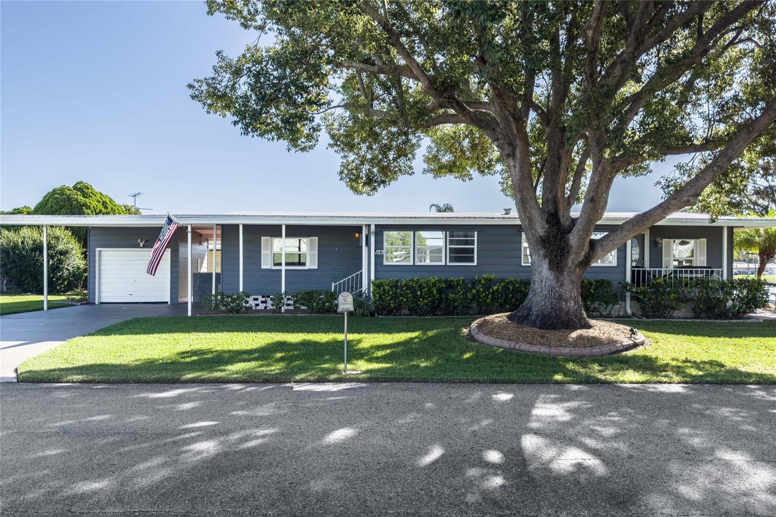 A slice of paradise awaits you on this beautiful corner lot at Betmar Acres, an active 55+ golf community where YOU OWN THE LAND.  A large wall of windows reveals panoramic views of the Memorial Pond, providing unobstructed views of the spectacular Florida sunrises and sunsets.  There are many updates in this well maintained  2BR/2BA home.  The exterior has been recently painted, landscaping updated,   membrane roof in 2018, and the AC replaced in 2015.  In the built-in bar area there is plumbing in place for a wet bar if desired.  Open floor plan and newer kitchen cabinets, extra deep sink, newer gas stove top, and countertops and closet pantry make cooking and entertaining a pleasure.  Two closets in indoor laundry, walk in closets in both bedrooms, an abundance of built in shelving and cabinets, coat closet,  provide lots of storage.  Double paned windows throughout the home (except for the Florida room), Other features include French doors leading from Florida room into kitchen, 11x15 one car garage with roll up door, painted driveway and mature landscaping.     The  primary bedroom is large enough for a king size bed, has walk-in closet, ceiling fan and ensuite bathroom with dual vanity, step-in shower and linen storage. Second bedroom has ceiling fan, walk-in closet and access to a full bath.  Betmar Acres offers 27 holes of golf, 2 swimming pools and 2 hot tubs along with 3 clubhouses, a library, walking paths, game rooms (Billiards, Table Tennis, Board Games) miniature golf, enclosed shuffleboard courts, tennis courts, pickle-ball courts, basketball court, Bocce courts, and Bingo. Main bedroom photo has been virtually staged.