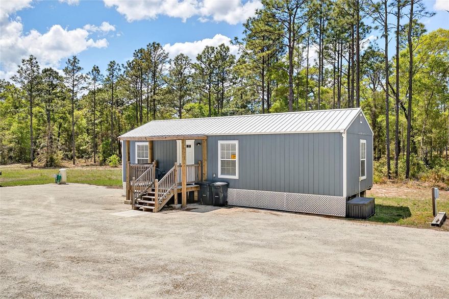 Welcome to this practically brand-new home, built in 2023, that is already operating as a successful 5-Star income-producing Airbnb. Whether you’re looking for a private retreat, investment property, or a place to build your dream home, this one checks every box. Situated on alittle over 5 acres, this property is cleared, prepped, and ready for a second home while you live in or rent out the existing home. The property features a 12’ wide horseshoe driveway and offers the perfect blend of privacy, functionality, and room to grow. There is also an RV hookup with water and dual-level power pole, adding even more flexibility for guests, travel, or additional income potential.

The home itself features 2 bedrooms and 1 bathroom with a bright, open layout and modern finishes throughout. Built with quality and efficiency in mind, the home includes Smart siding, moisture-barrier wrapped walls, and a 29-gauge metal roof with a 40-year warranty and underlayment. Inside, you’ll find spray foam insulation in both the ceilings and floors, cathedral ceilings, and custom cabinetry, creating a space that feels both cozy and elevated. The kitchen is thoughtfully designed with custom cabinetry, newer appliances, Kohler fixtures, and a farmhouse sink, flowing seamlessly into the main living space. Waterproof flooring runs throughout, and the bathroom includes a convenient washer/dryer combo.
Outside is where this property truly shines Enjoy a covered front deck, fire pit, cast iron grill, and wide open space surrounded by nature. The land is filled with naturally growing blackberries, blueberries, and more, creating a peaceful setting that feels like your own private escape. Utilities are designed to be self-sufficient, featuring a 118-ft well with a whole-house 3-stage filtration system (installed 2023) for pristine, great-tasting water, along with a dual-capacity septic system (installed 11/2023) already set up for an additional home. Underground electric keeps the landscape clean and unobstructed. Additional features include a large crushed concrete parking area, 60” Spartan zero-turn mower included, and the property is being offered FULLY FURNISHED. With so many possibilities — live in it, rent it, expand it, or build your dream home while generating income...this is a property that truly stands out. Opportunities like this don’t come around often; schedule your showing today.