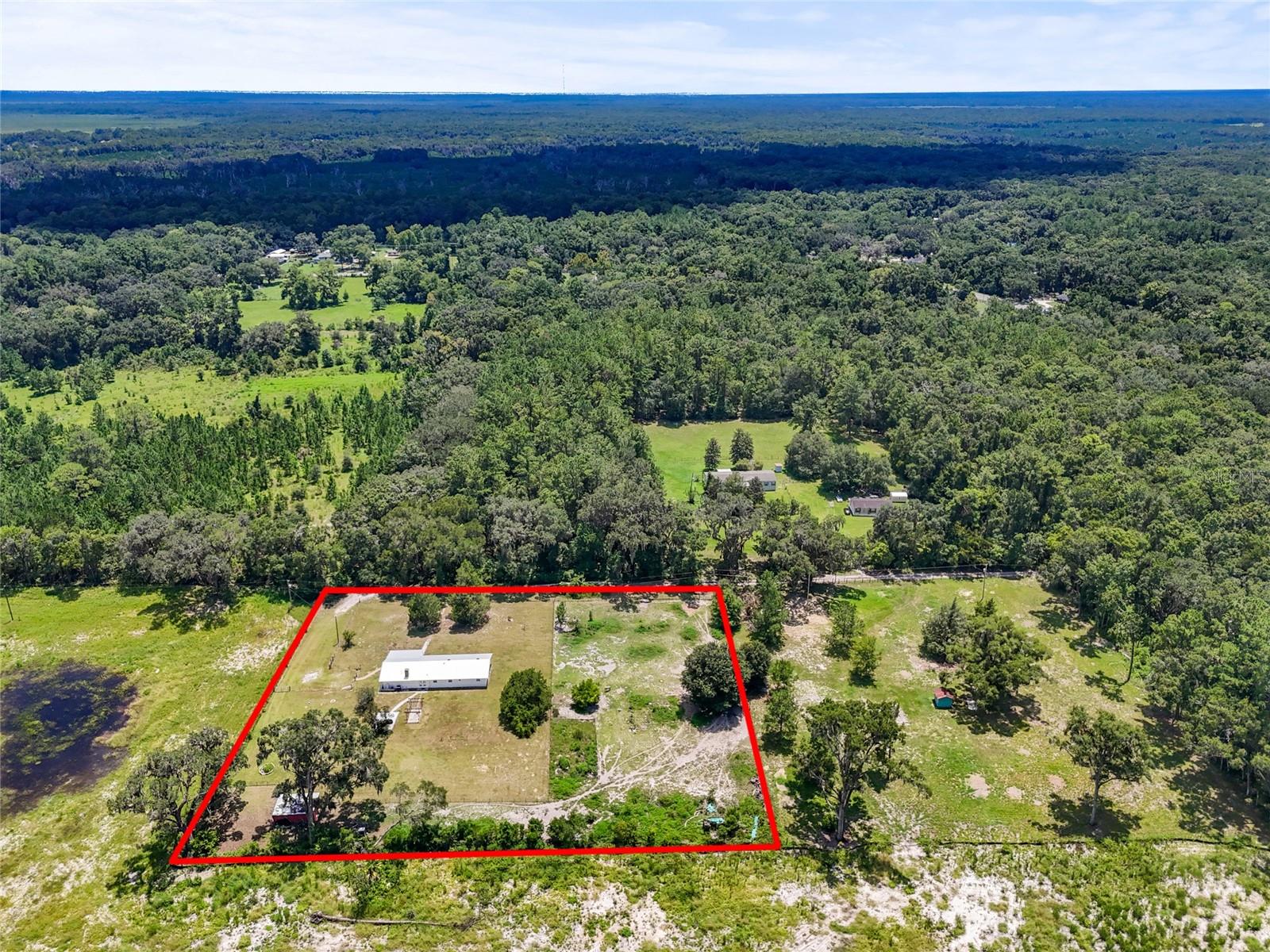 Dreaming of a renovated concrete block home on over 2 acres with no deed restrictions, and all within 15 minutes of UF? This move-in ready 4-bedroom, 2.5-bath ranch checks nearly every box, from updated interiors to expansive outdoor living.
Step through the front door into a spacious, light-filled layout. The main living space is anchored by a stately brick fireplace, creating a cozy atmosphere for hosting game and movie nights or a quiet night in. The updated kitchen is a true centerpiece, stretching from the dining space and comes complete with a dry bar and wine rack. The main work space is where you’ll find a gas stove, stainless steel appliances, soft-close off-white cabinets with hand-glazed detailing, granite countertops, and a farmhouse sink. Porcelain tile floors tie it all together for a clean, modern feel.
Three bedrooms, including the original primary suite with an attached half bath, are tucked to one side of the home, each featuring bamboo flooring. Off the cozy family room, you’ll discover a laundry room and a gorgeous owner’s suite addition. This retreat boasts a spa-like en suite bathroom with floor-to-ceiling tile, dual vanity, soaking tub, and a walk-in shower.
Outside, the lifestyle continues. Enjoy your mornings on the patio beneath the pergola, weekends around the fire pit, and afternoons tending your thriving garden. The 2,000 sq ft irrigated and fenced plot is perfect for growing your own produce, and more than 20 mature fruit trees (9 different varieties) make this property a true urban homestead. A separate storage shed and full perimeter fencing round out this exceptional offering. Bring your farm animals! The chicken coop is awaiting its new occupants.
