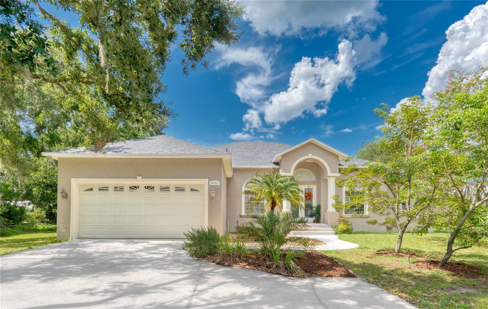 Welcome to your own private retreat in Plant City! Situated on over 2 acres of beautifully maintained land, this spacious 3-bedroom, 3-bathroom, 2-car garage home offers the perfect blend of indoor comfort and outdoor living. The property highlights include a productive orchard and garden, lush landscaping, a large metal garage/workshop, and a huge screened lanai.
Inside, the home features a split-bedroom layout that gives everyone their own space. The primary suite is tucked away on one side of the house for added privacy and includes a walk-in shower, soaking tub, and linen closets. On the opposite side, you’ll find two additional bedrooms—each with their own bathroom. One has a walk-in shower and the other a tub, making it ideal for families or guests.
As you enter the home, you’re greeted by a welcoming foyer and to the right French doors leading into a bright office or den with beautiful arched front windows—a feature also found in the formal dining room, filling the space with natural light.
The heart of the home is the open floor plan that connects the living room with a cozy brick fireplace, the kitchen, and the eat-in kitchen. The kitchen is equipped with granite countertops, bar seating, and a new range, along with a one-year-old microwave, dishwasher, and refrigerator. Just off the kitchen, a laundry room connects to the attached two-car garage—and the washer and dryer are just two years old.
Just off the living room, sliding doors open up to the expansive screened lanai, perfect for relaxing or entertaining with views of your garden and orchard. The fruit orchard is irrigated with a timer-controlled underground system and can supply a variety of fruit year-round for 2–3 adults. The vegetable garden is also fully irrigated with overhead and drip systems on a timer, and there’s even an outdoor outlet already in place if you'd like to install a spa or jacuzzi.
The detached metal garage/workshop is wired with electricity, has plumbing ready for a toilet or washer, is set up with a generator outlet, and is large enough to accommodate the install of a car lift—ideal for a serious hobbyist or anyone needing additional work or storage space.
Additional recent updates include a brand-new roof and fresh exterior paint—both completed in 2025.