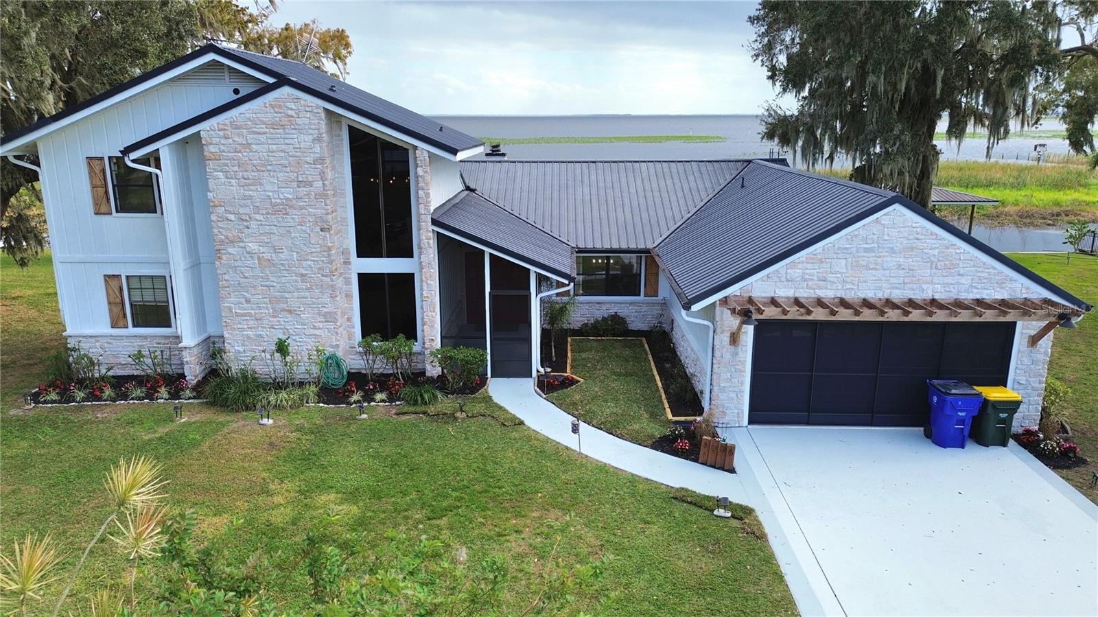 Have you been dreaming of a lakefront retreat? Here’s your opportunity to live on one of the finest lots and views on the main body of Lake Istakpoga. This stunning home features over 140 feet of shoreline complete with a seawall. The two-story custom design showcases breathtaking lake views throughout and embraces a charming modern French country farmhouse aesthetic. The property includes three bedrooms and three bathrooms, along with a two-car garage. It has been fully renovated with beautiful stone accents inside and out, and new flooring runs throughout the entire house. An elegant stone fireplace provides a cozy ambiance while offering views of the lake. The kitchen has been remodeled with specialty granite and brand-new appliances, while the bathrooms exude a spa-like atmosphere. Enjoy the new covered wrap-around porch that extends along the entire back of the house, leading to your private 24-foot boathouse equipped with a 4500 lb lift.