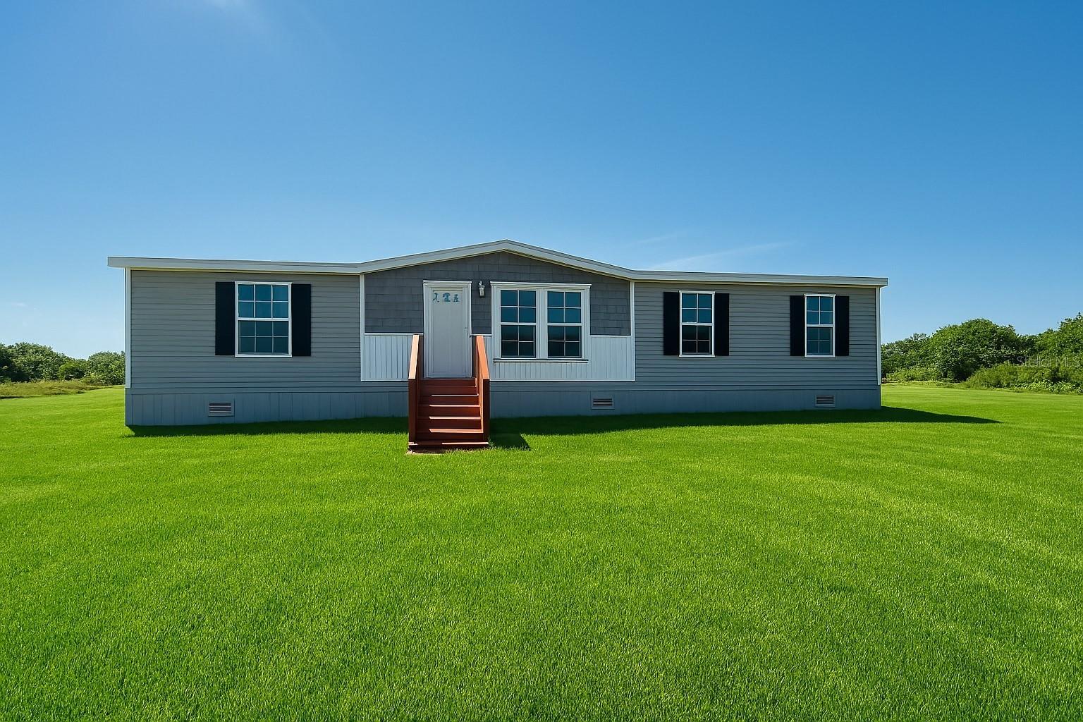 Pre-Construction. To be built. Brand New 3BR/2BA | 1.25 Acres | Prairie/Viking Community Move-in ready and beautifully upgraded, this 1,493 SqFt Champion Embrace home offers a modern split floor plan with warm wood tones, accent walls, and contemporary interior design throughout. The spacious kitchen features a coffee bar, built-in microwave, pantry cabinet, large island with pendant lighting, and contrasting countertops. A separate dining area flows into the inviting living room, while the interior laundry room includes built-in cabinets and a hanging rack for added convenience. The private primary suite is designed for comfort, offering a standalone soaking tub, oversized walk-in shower, double vanity, and tall linen cabinet. Additional upgrades include finished drywall throughout, stainless steel appliances, black fixtures, and walk-in closets. Set on a beautiful 1.25-acre AG-zoned lot, this property is perfect for animals, recreational vehicles, and future plans for a barn, garage, or pool. Conveniently located just a short drive from Lake Okeechobee and the City of Okeechobee for shopping, dining, and medical services. Seller has additional move-in-ready homes available. Schedule your showing today!Photos are for illustration purposes only and may depict a similar home. Actual finishes, colors, and features may vary.