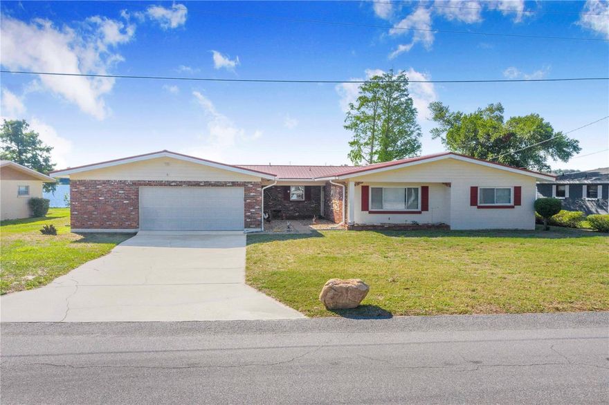 Tucked away on a dead-end street in Winter Haven, this spacious lakefront home on Lake Buckeye offers almost 2,400 square feet of living space, a private dock, and a rare combination of privacy, character, and major updates. Situated on over 1/3 of an acre, the property features low traffic, peaceful waterfront views, and a fenced backyard area for pets or animals.
Inside, you’ll find a massive living room with triple sliding glass doors overlooking the lake, a floor-to-ceiling stone wood-burning fireplace, and beautiful wood ceilings that create a warm lakeside atmosphere. All 4 bedrooms are positioned on one side of the home, while the oversized living and entertaining areas maximize the waterfront setting and provide excellent flexibility for future remodeling or customization.
Major improvements include a metal roof (2019), HVAC system (2016), water heater (2018), upgraded double-pane storm-resistant windows (2010), re-piped plumbing, septic pumped in July 2025, new drain field installed in 2025, and refrigerator replaced in 2023.
Lake Buckeye provides a more private setting with fewer homes on the lake while still providing public boat ramp access. Conveniently located a few miles from downtown Winter Haven and only about a mile from Polk State College, this property combines waterfront living, space, and long-term value in a highly convenient location.