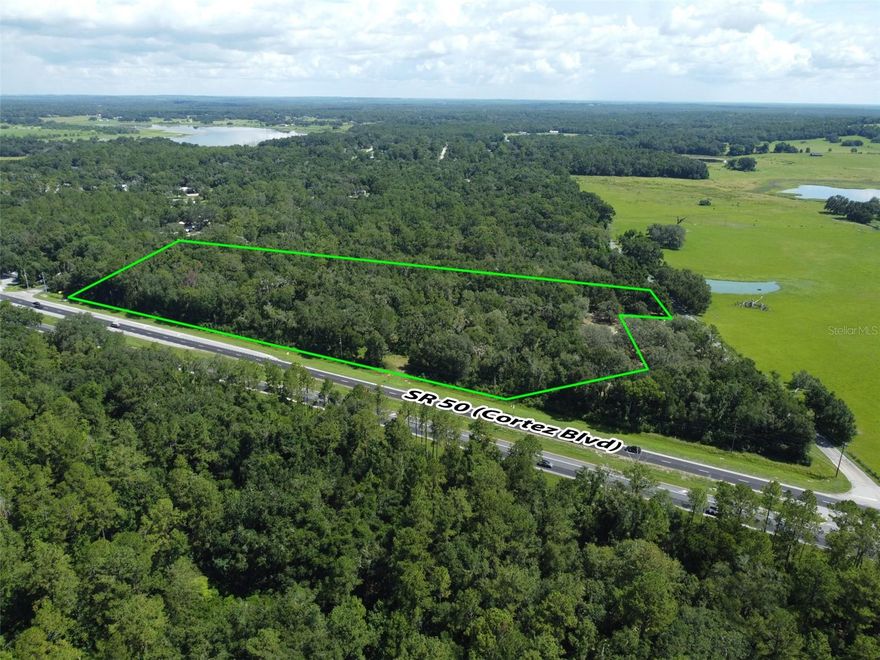 Outstanding commercial development opportunity along one of Hernando County’s most traveled corridors. This 11.90-acre parcel features approximately 826 feet of frontage on Cortez Boulevard (State Road 50), with an Average Annual Daily Traffic (AADT) count of 29,500 vehicles per day. Zoned C1 at the front and AG at the rear, the property is ideally suited for a wide range of commercial applications—retail, fast-casual or quick-service dining, medical, office, or mixed-use development—subject to county approval. A conceptual site plan has been prepared by PROCIVIL 360, providing a strong foundation for development. Water service is conveniently available from WPA Road. As is typical for this market, municipal sewer service is not available; however, septic systems are widely accepted and utilized throughout the area, making this a practical and feasible option for new development. Located just minutes from the Historic City of Brooksville, this site combines modern development potential with small-town charm. Brooksville is known for its tree-lined streets, preserved architecture, and vibrant downtown—hosting seasonal festivals, farmers markets, and a growing local business scene. This blend of historic character and forward-looking growth has made the area increasingly attractive to both residents and commercial developers. The property is strategically positioned between two major transportation arteries—just 5 miles from Interstate 75 and 10 miles from the Suncoast Parkway—offering exceptional regional connectivity. It is also 12 miles from the Brooksville–Tampa Bay Regional Airport and 50 miles from Tampa International Airport. Downtown Tampa is 45 miles away, while Clearwater Beach, St. Petersburg, and Orlando are all within 63 to 70 miles—placing the site within reach of four major metropolitan areas. For national retailers, commercial builders, and investors seeking visibility, flexibility, and long-term upside in a high-growth corridor, this is a rare and compelling opportunity.