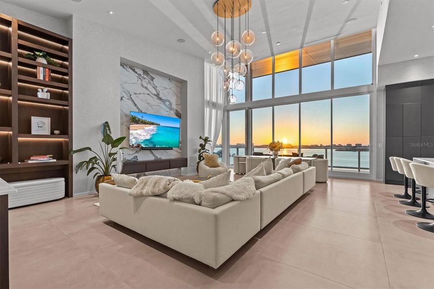 One or more photo(s) has been virtually staged. Sky Penthouse 703 at Serena by the Sea delivers rare 16’+ ceilings, floor-to-ceiling glass, and unobstructed Gulf-to-Intracoastal panoramas. Retractable sliders open to colossal west facing terrace with no adjacent balconies for true privacy. 3 ensuite bedrooms + office + theater room. Italian kitchen with waterfall stone and full Gaggenau suite appliances. Whole-home automation wiring, integrated audio, and electric blackout shades. Spa-style primary bath with soaking tub; large laundry; climate-controlled storage; three parking spaces next to the private elevator lobby. 23,000± SQFT resident-only amenities: zero-edge heated saltwater pool with cabanas, outdoor kitchen & sunset fire pit; modern fitness center; European-style spa with sauna, cold-plunge bucket, massage suites, jacuzzi & relaxation lounge. Exclusive access to concierge wellness services via a preferred provider. Marina in progress with priority slip rights for PH703. Recent appraisal valued at $4.8M! Furniture and electronics do not convey.