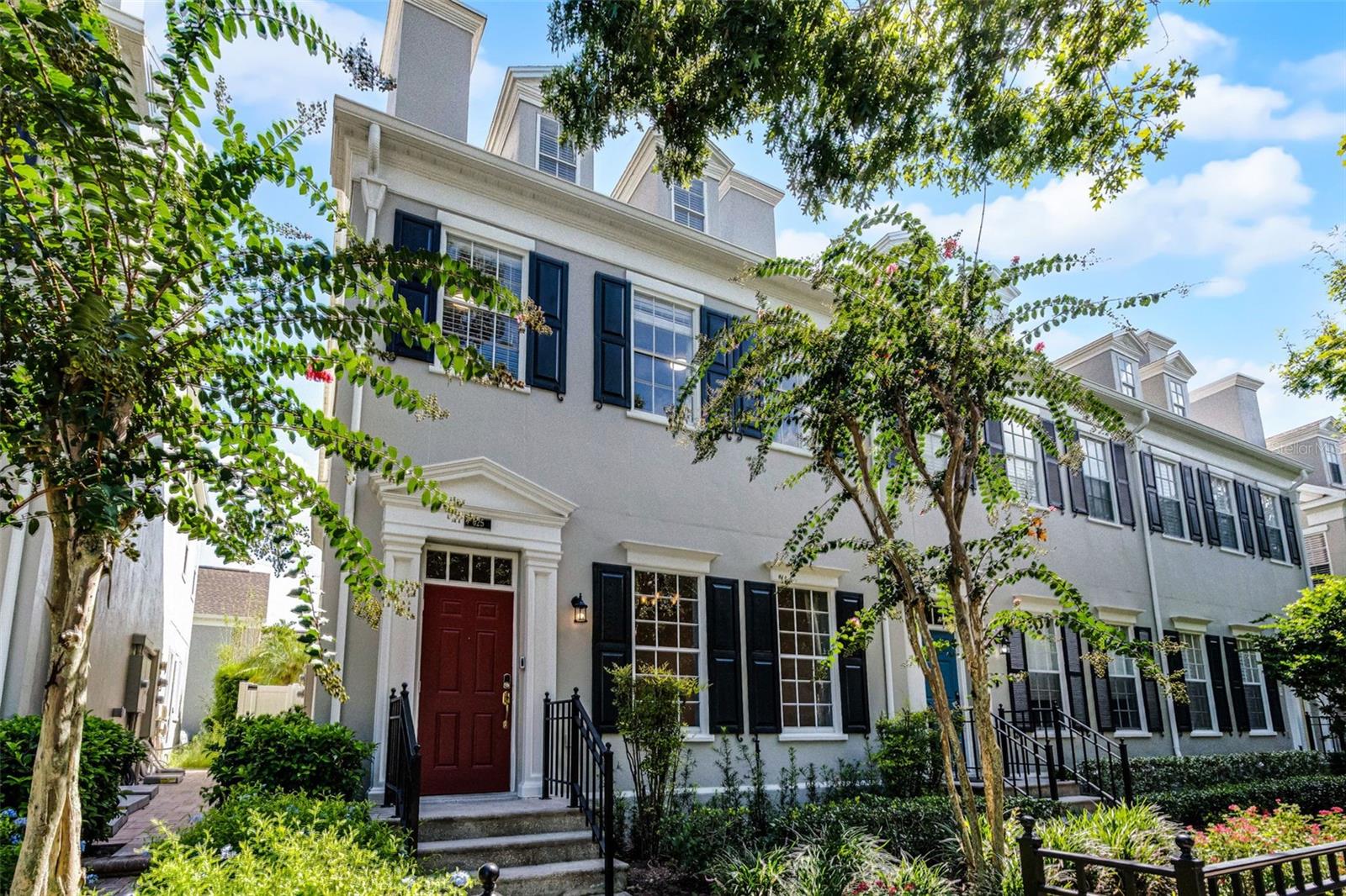 Welcome to a residence that embodies elegance, craftsmanship, and the timeless charm of Celebration, Florida. Tucked away in the heart of Celebration’s sought-after downtown Main Village, this exquisite four-bedroom, three-story townhome is a rare gem that combines sophisticated design with an unparalleled location. From the moment you step inside, you’re welcomed by a grand open foyer adorned with rich California hickory hardwood flooring and detailed 5¼" baseboards that gracefully flow throughout the main living spaces. The expansive dining and family room invite refined entertaining and everyday comfort alike. The thoughtfully designed kitchen is a true culinary showcase, featuring custom 42" white espresso cabinetry with crown molding and glass inserts, sleek granite countertops, and a striking glass mosaic tile backsplash. High-end stainless steel appliances include a VIKING microwave, GE Monogram dishwasher, a side-by-side refrigerator, and a glass-top range. A charming breakfast nook offers the perfect perch to enjoy morning coffee while overlooking the beautifully manicured yard. Upstairs, the luxurious primary suite serves as a serene escape, boasting a spa-inspired en suite bathroom complete with a soaking tub, glass-enclosed shower, dual vanity, mosaic tile accents, and oversized tile flooring. Two additional guest bedrooms and a full bath complete the second floor. Ascend to the third level to discover an expansive fourth bedroom with a large walk-in closet—ideal as a guest suite, home office, media room, or private retreat. Living in Celebration means more than just owning a home—it means embracing a lifestyle. Residents enjoy access to community pools, picturesque parks, playgrounds, and over 26 miles of scenic trails for walking and biking. With world-class dining, charming boutiques, and vibrant year-round events just steps away, this home offers the perfect blend of sophistication and convenience. Don’t miss the opportunity to own a true piece of Celebration’s architectural and cultural heart.