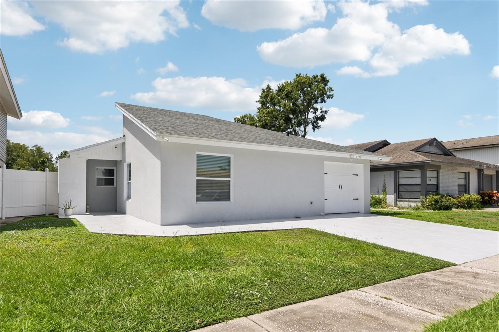 Welcome to 10329 Delmar Circle, a beautifully renovated 4-bedroom, 2-bathroom home located in the desirable Plantation subdivision, a community known for its LOW HOA and NO CDD! Nestled among 55 acres of tranquil lakes and 64 acres of recreational space, this neighborhood offers an unbeatable lifestyle. Enjoy top-notch amenities including tennis courts, soccer fields, swimming pools, and multiple playgrounds, all included with low fees. This charming single-story residence offers modern comfort, thoughtful design, and a fantastic location all in one. Featuring a 2-year-old roof and newer stainless steel appliances, this home is move-in ready with major systems already updated for peace of mind. As you approach the property, you’ll notice its clean, modern curb appeal with fresh exterior paint and a wide driveway. The garage has been professionally converted into a spacious fourth bedroom complete with its own egress door, making it ideal for extended family, guests, or use as a private home office. Inside, the home impresses with vaulted ceilings and sleek white marble-look porcelain tile flooring that flows throughout the main living areas. The open-concept living room is filled with natural light and seamlessly connects to a stylish kitchen featuring granite countertops, white shaker cabinetry, glass tile backsplash, and updated stainless steel appliances. French doors lead from the living space to a large backyard patio, offering the perfect setup for indoor-outdoor living. All four bedrooms are well-sized and include ceiling fans and ample closet space. The two full bathrooms have been fully remodeled with contemporary tile work, modern vanities, and walk-in glass showers. The converted garage not only enhances the square footage but also offers a separate entrance, making it a versatile space for multi-generational living or even a potential rental setup. The backyard is fully fenced and includes a large concrete patio, great for entertaining or simply relaxing in privacy. Aerial views reveal that the home is located on a quiet loop street within the Plantation community, with no immediate rear neighbors and nearby green space providing a tranquil buffer. Conveniently located with easy access to major roads such as the Veteran’s Expressway and Dale Mabry Highway, you're just minutes from shopping centers, grocery stores, Tampa International Airport, Raymond James Stadium, and George M. Steinbrenner Field, home of the Tampa Tarpons. With its modern updates, low-maintenance layout, and prime location, this home is ideal for first-time buyers, families, or investors looking for a quality property in a well-established neighborhood. Schedule your private tour today and see why 10329 Delmar Circle is the perfect place to call home.