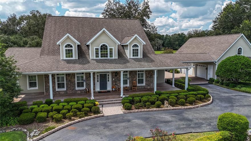 Welcome to this stunning 5-bedroom, 6-bathroom, 4,871 SF (8691 total) custom American Farmhouse on 10.5 acres in the gated community of Equine Estates. Built by Mega Construction in 2006, this exceptional home is crafted for those who value fine craftsmanship, privacy, and an equestrian lifestyle. Enjoy direct access to the 110-mile Marjorie Harris Carr Cross Florida Greenway—ride straight from your property to the Florida Horse Park, or explore three miles of private community bridle paths beneath majestic granddaddy oaks.

Main Residence: 

Showcasing timeless design and top of the line materials with all original receipts. The exterior features Hardie board siding, stone veneer accents, a steep gable roof, dormer windows and a large welcoming Brazilian hardwood porch with columns. Step into the two-story coral stone foyer, where a custom red oak staircase and balcony rail set an elegant tone carried throughout the home.

The great room impresses with a cathedral beamed tray ceiling and an architectural stone floor-to-ceiling handcrafted fireplace  complemented by a towering custom red oak entertainment center that echoes the home’s stunning staircase and flooring. 

The gourmet kitchen is a chef’s dream—granite countertops, shaker cabinetry, coral stone floors, pendant lighting, dual pantries, and island seating. A laundry room off the kitchen continues the fine craftsmanship with matching shaker cabinetry and coral stone flooring. The   kitchen has an eat-in area, plus an additional formal dining or secondary kitchen space off the great room—

The primary suite is a true retreat with red oak flooring, plantation shutters, a serene sitting retreat overlooking the pool and pastures and a spa-inspired bath featuring coral stone floors, dual stone vanities, a soaking tub encased in stone, and a glass shower with coral stone flooring.

Upstairs, three spacious ensuite bedrooms feature Kohler fixtures, Corian vanities, and frameless glass showers, while an additional 810-square-foot finished space above the three-car garage with a private entrance and half bath providing a perfect gym, office, or guest suite.

Outdoor Living:

Step through the French doors to a vaulted, screened lanai wrapped in rich Brazilian hardwood decking, where a warm oak ceiling and a floor-to-ceiling stone fireplace—designed for both gas and wood burning—create the perfect backdrop for every season. The lanai offers a picturesque vantage point overlooking the saltwater pool, horse barn, and sunlit pastures.

Equestrian Barn:

The 2,548-square-foot center isle block barn is designed for function and comfort, featuring four stalls, an Air conditioned tack and feed room, two hot/cold wash racks, a shoo fly system and a dedicated equipment room featuring workbenches and shelving along with a climate-controlled office with half bath providing convenience and comfort.

The property’s lush 10.5-acre pastures are fully fenced and cross fenced, offering an ideal setup for horses and cattle.

Modern Systems & Features:

5-unit multi-zone HVAC (2 new 2025; 4 home + 1 barn office)-

Whole-house Generac generator (July 2025 service)-

Dual propane tanks-

Updated water heaters, bladder tank (2024), irrigation (2025 panel)-

NuTone central vac, 10-year termite bond (to 2035)-

Porte-cochère with 30-amp RV hookup for vehicles or guest use.